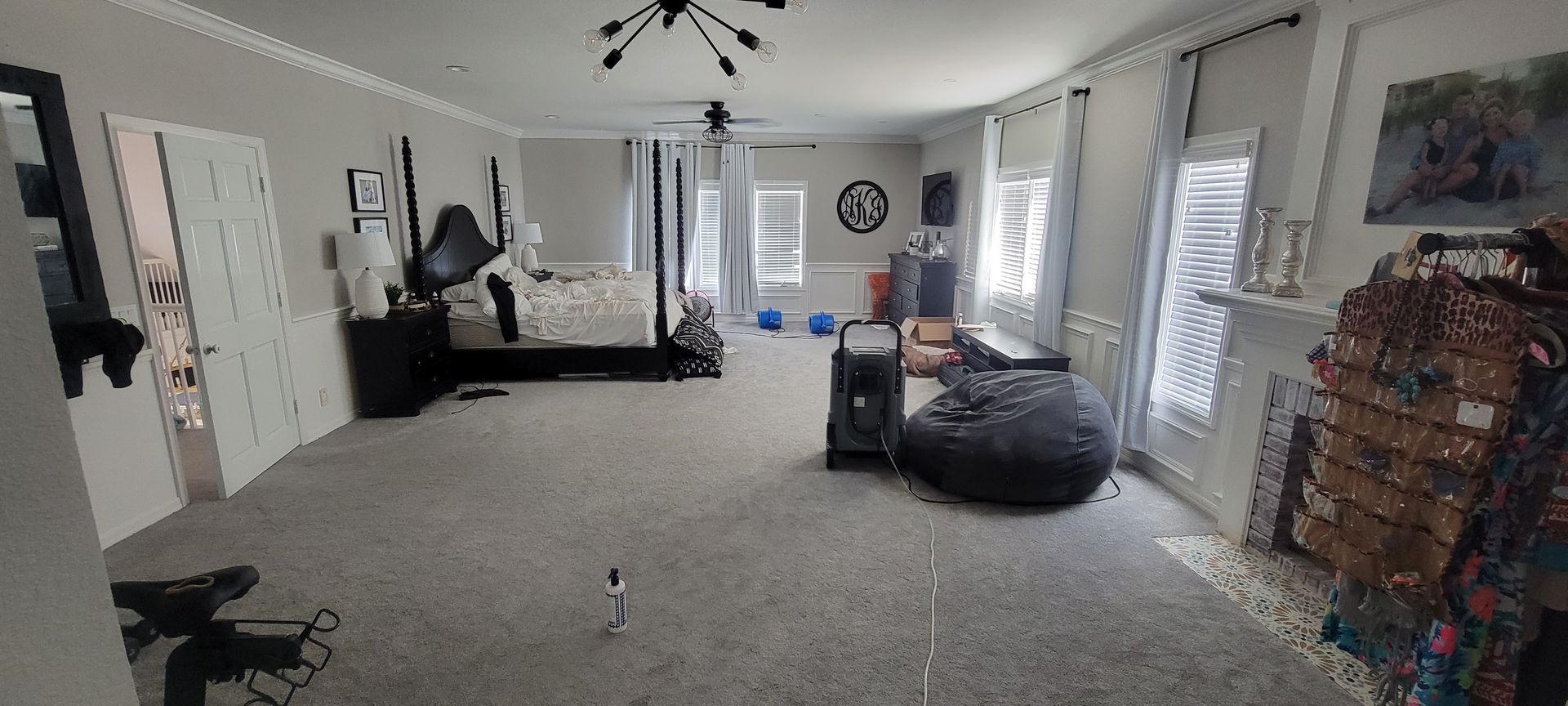 A large room with a bed , chairs , a speaker and a fireplace.