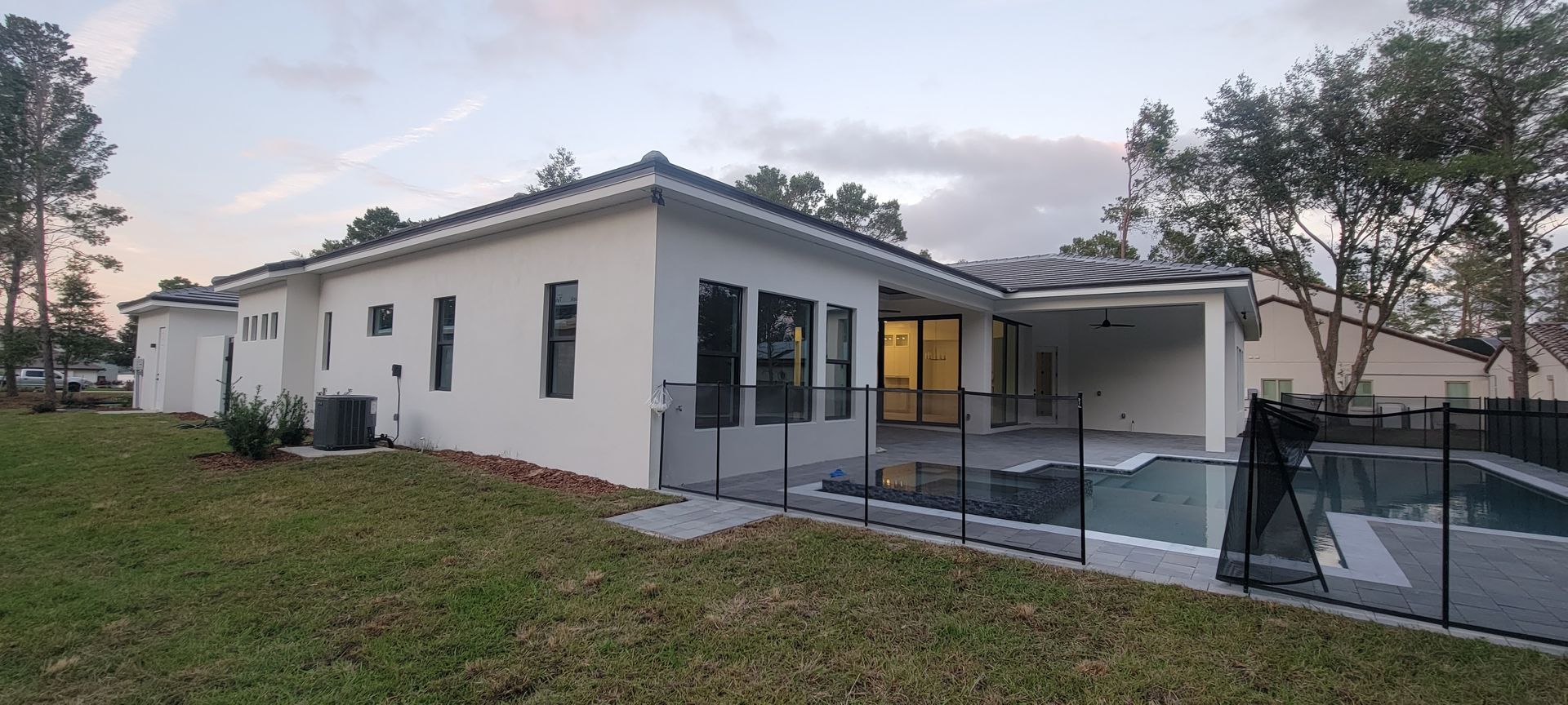 A white house with a fence around it and a pool in the backyard.