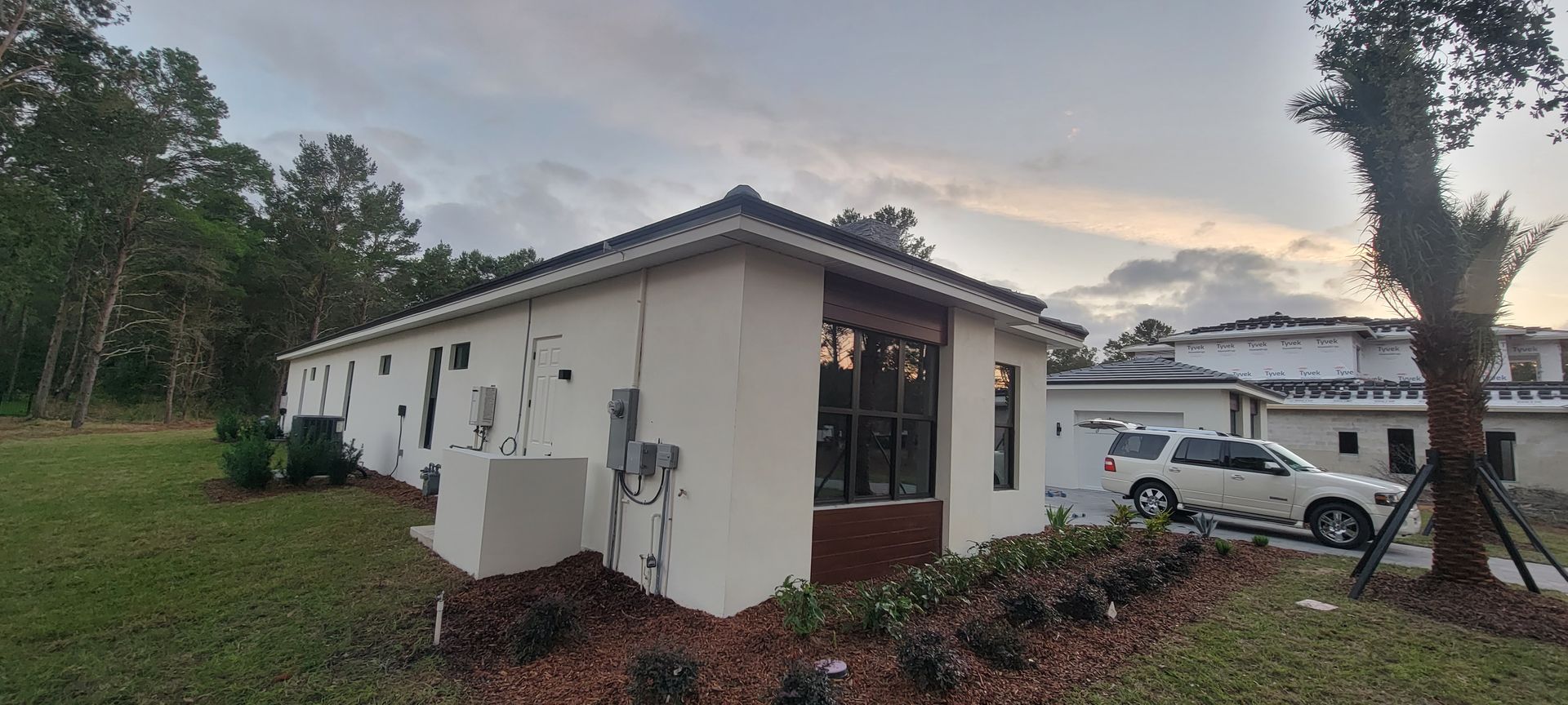 A white house with a car parked in front of it.