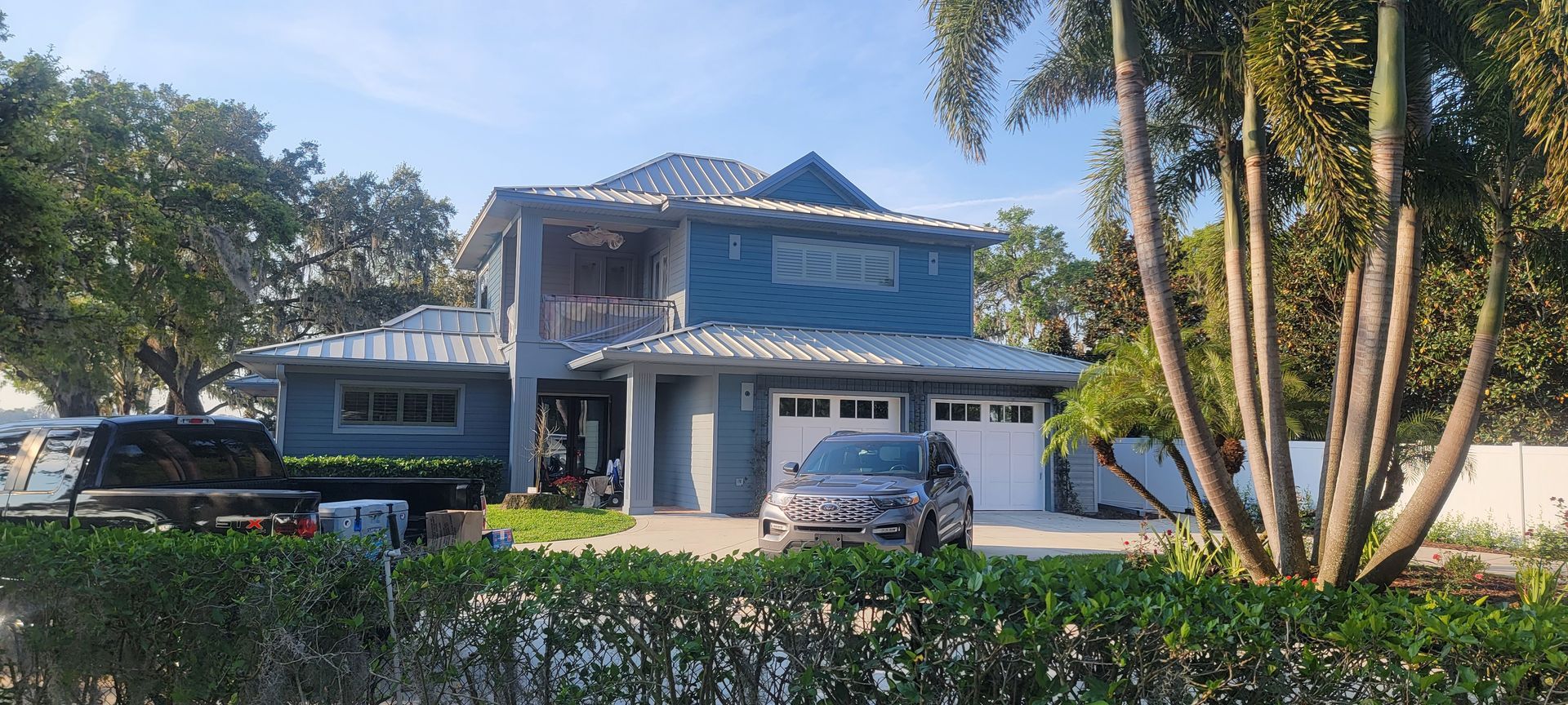A large blue house with a car parked in front of it.