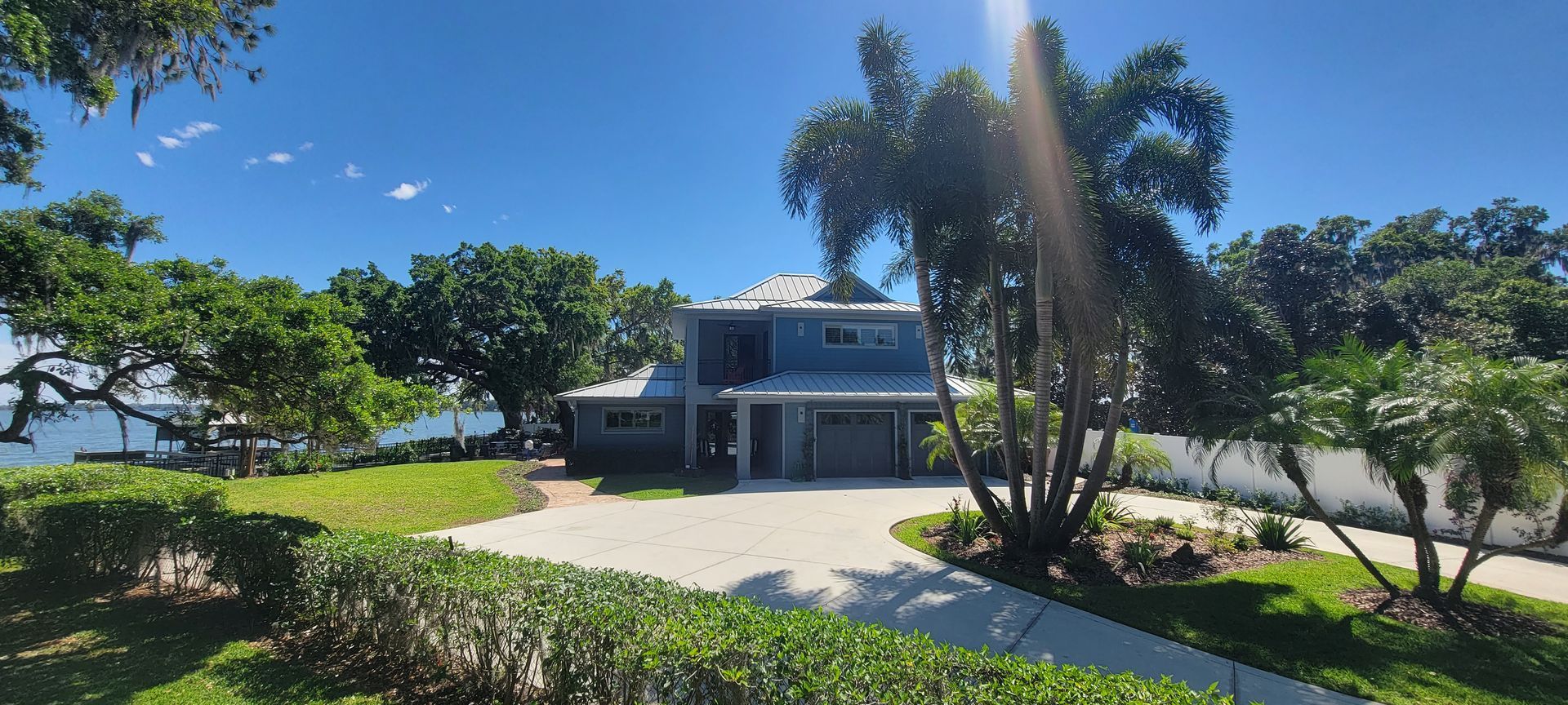 A large blue house with a lot of trees in front of it.