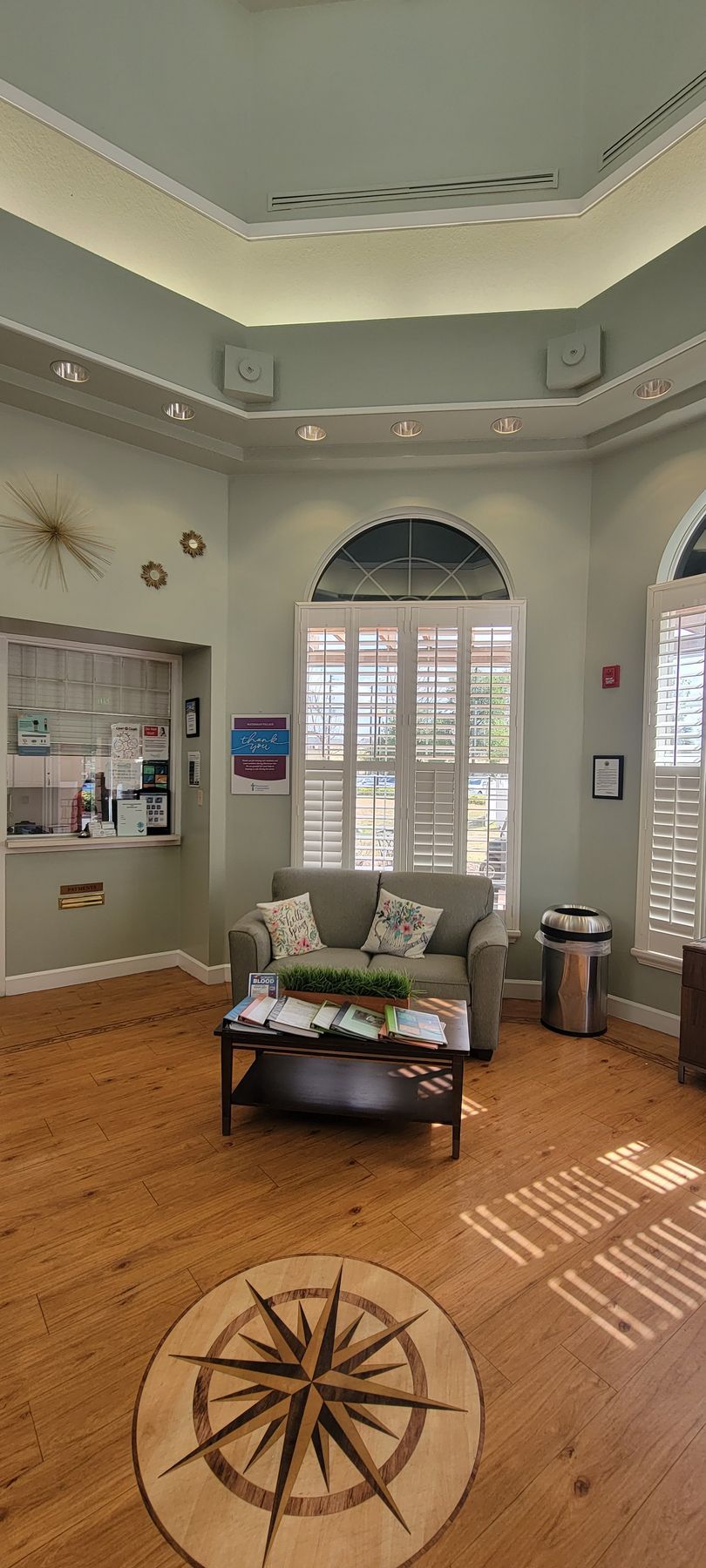 A living room with a couch , coffee table , and a compass on the floor.