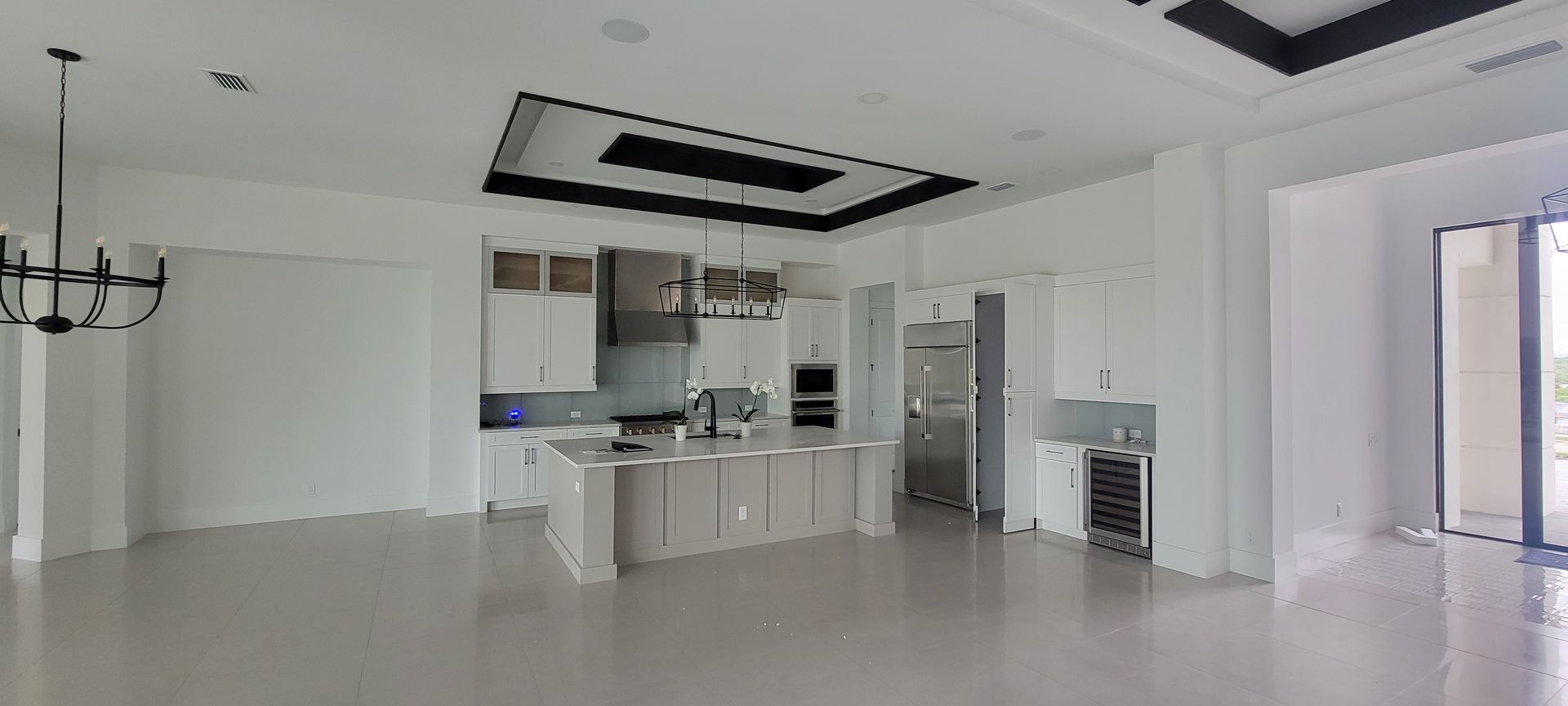 A large empty room with a kitchen and dining room in it.