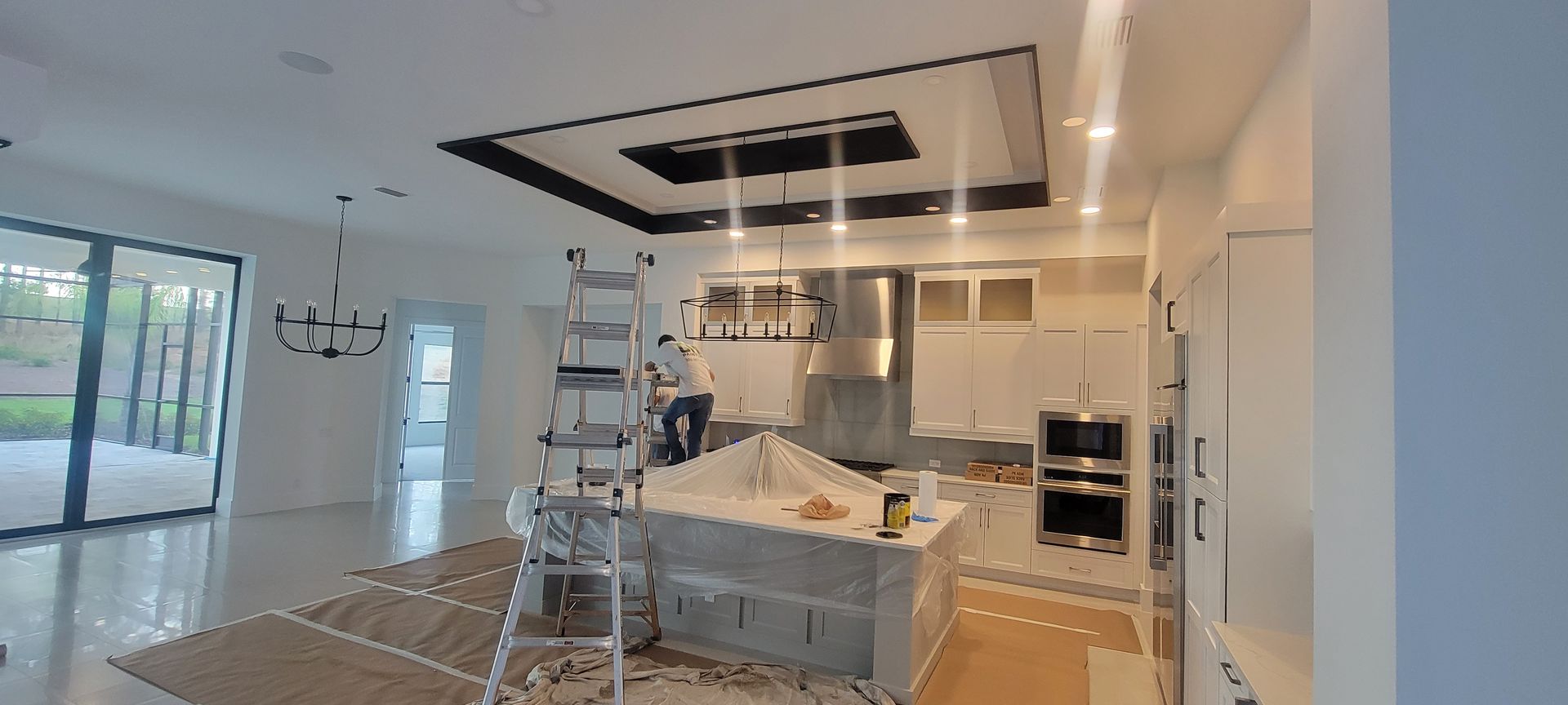 A kitchen is being remodeled with a ladder in the middle of the room.