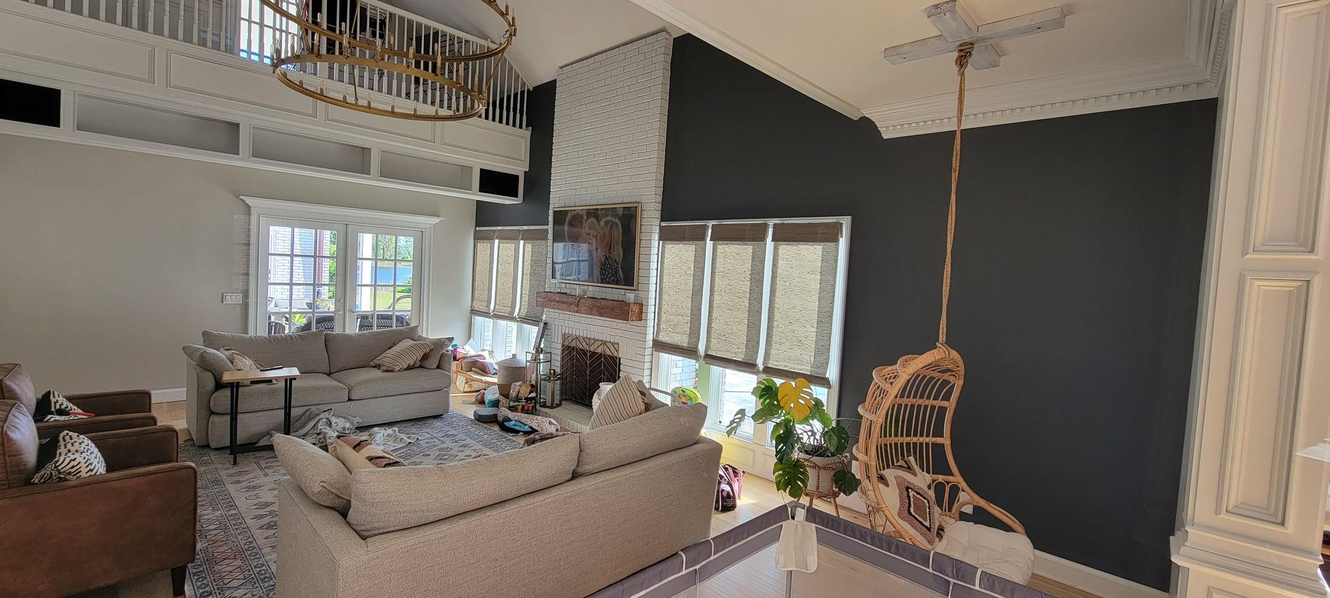 A living room with a couch , chair , fireplace and chandelier.
