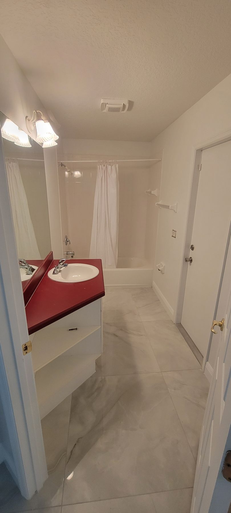 A bathroom with a sink , mirror , tub and shower.