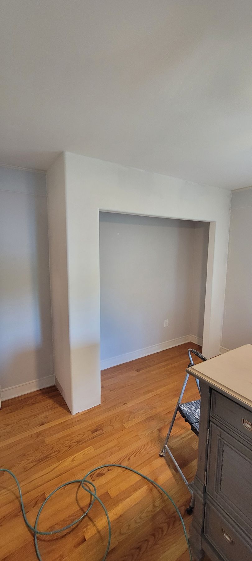A living room with hardwood floors and white walls.