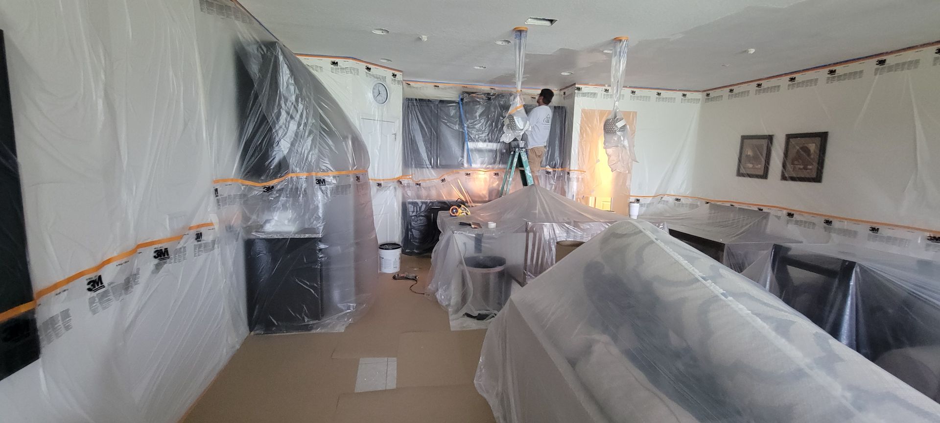 A room is being painted and covered in plastic.