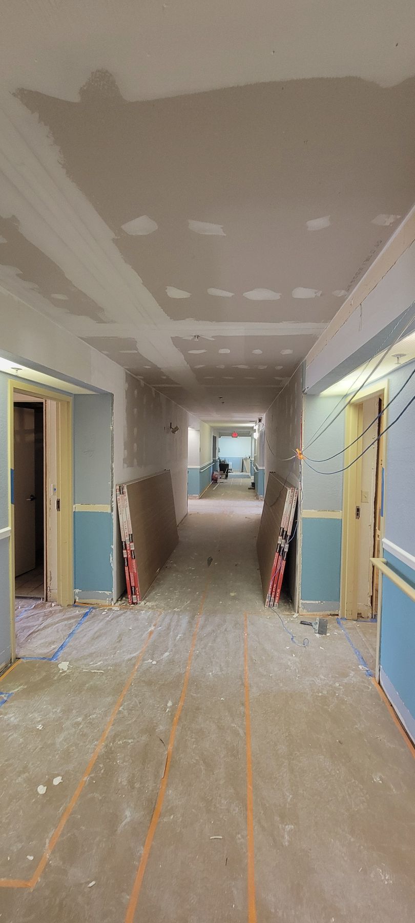 A long hallway in a building that is being remodeled.