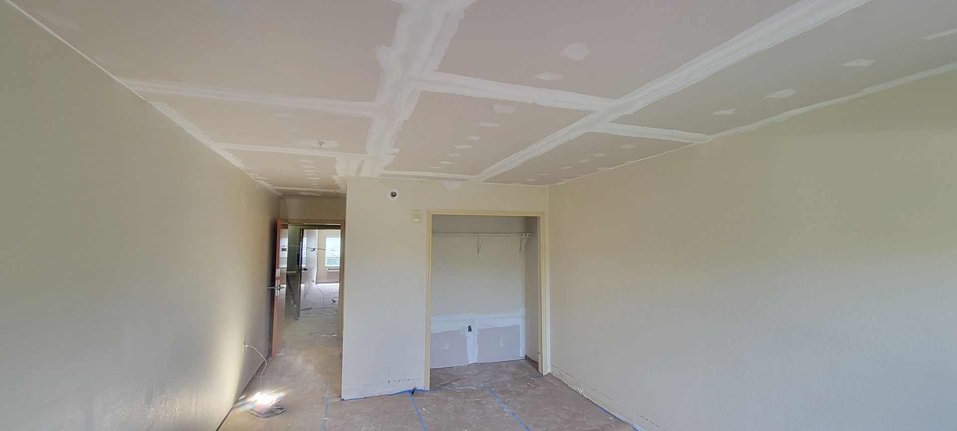 An empty room with drywall on the ceiling and walls.
