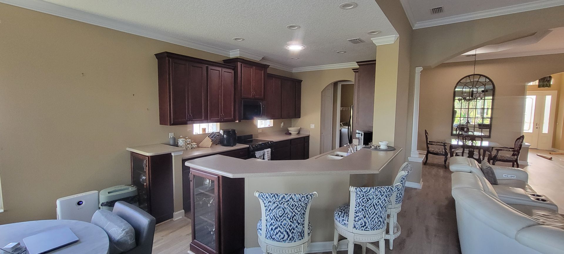 A kitchen with a bar and chairs in a house