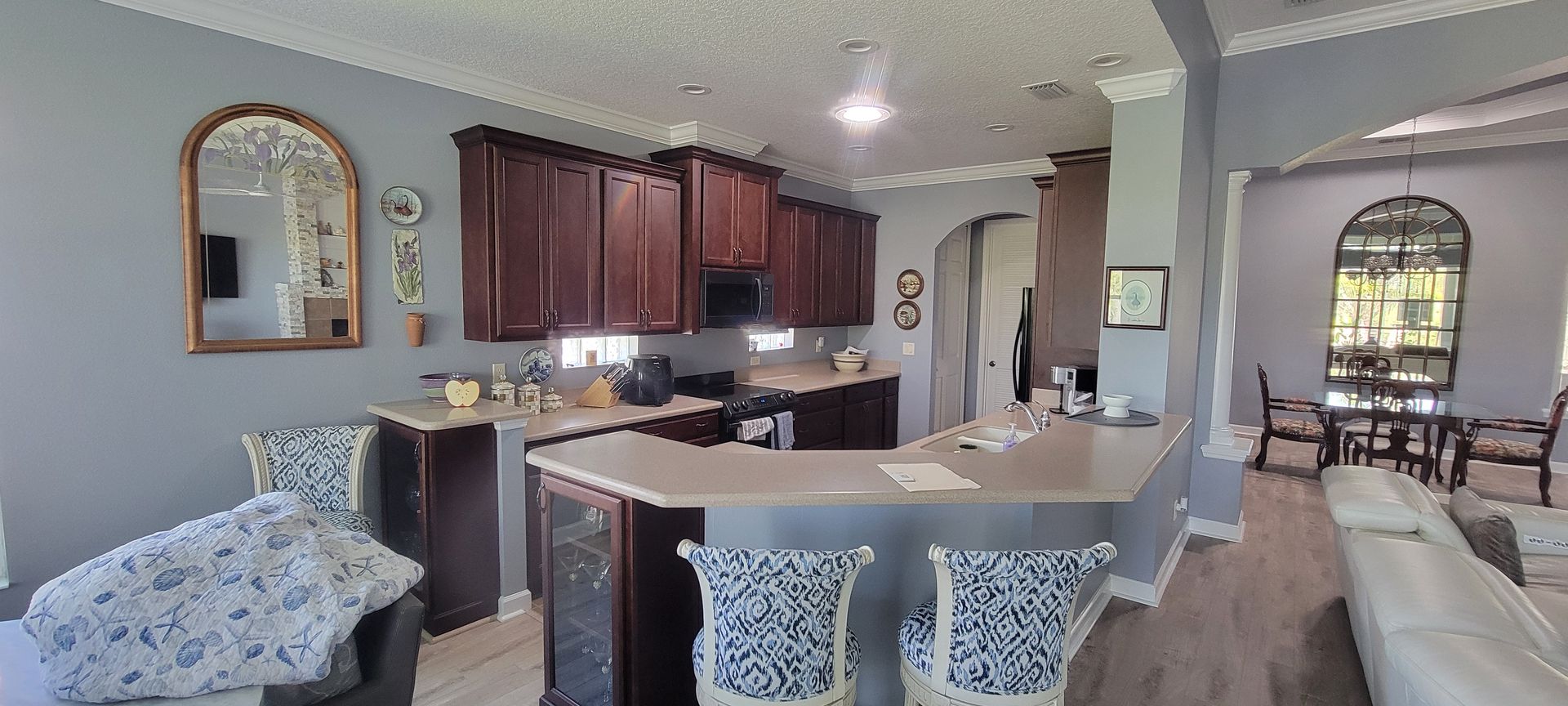 A kitchen with a bar and a dining room in the background