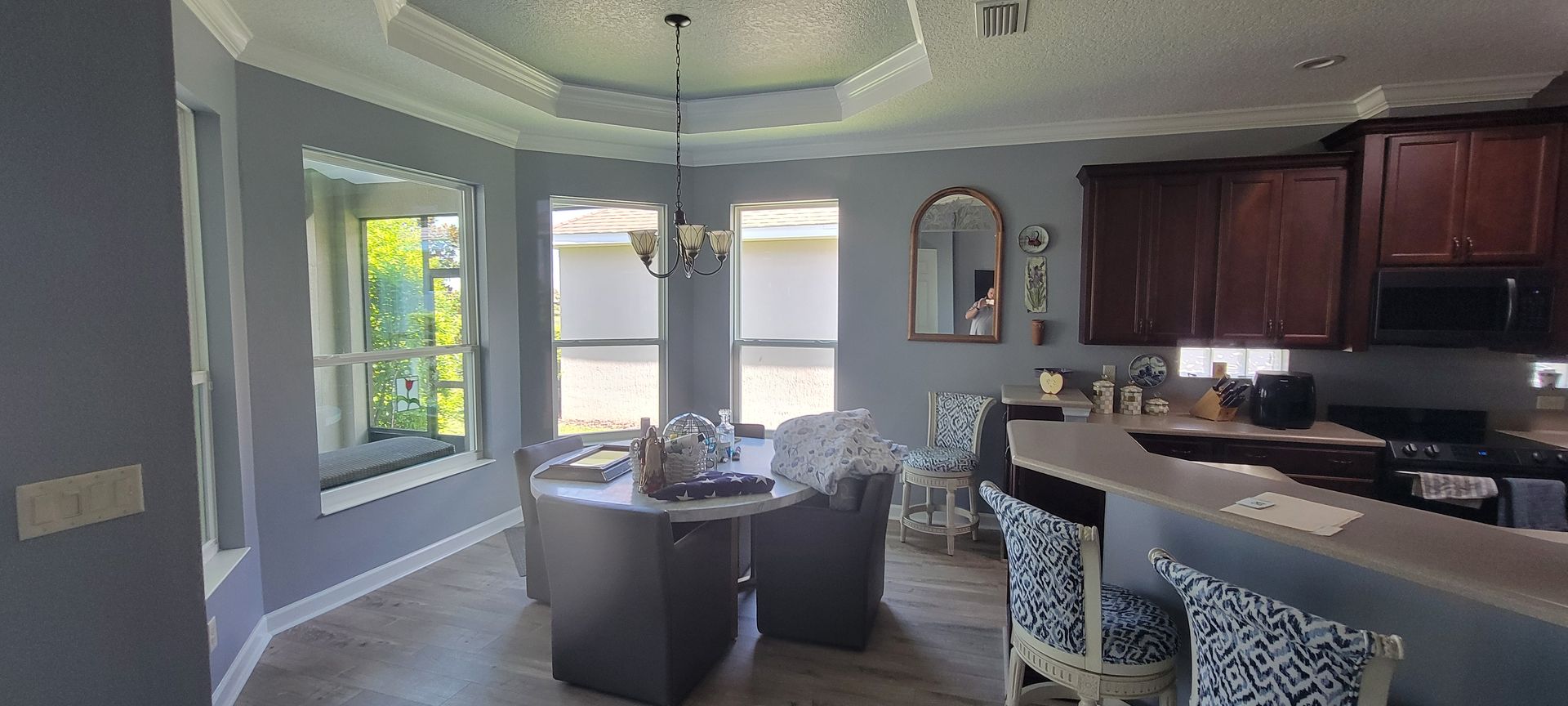 A kitchen with a table and chairs and a chandelier hanging from the ceiling.