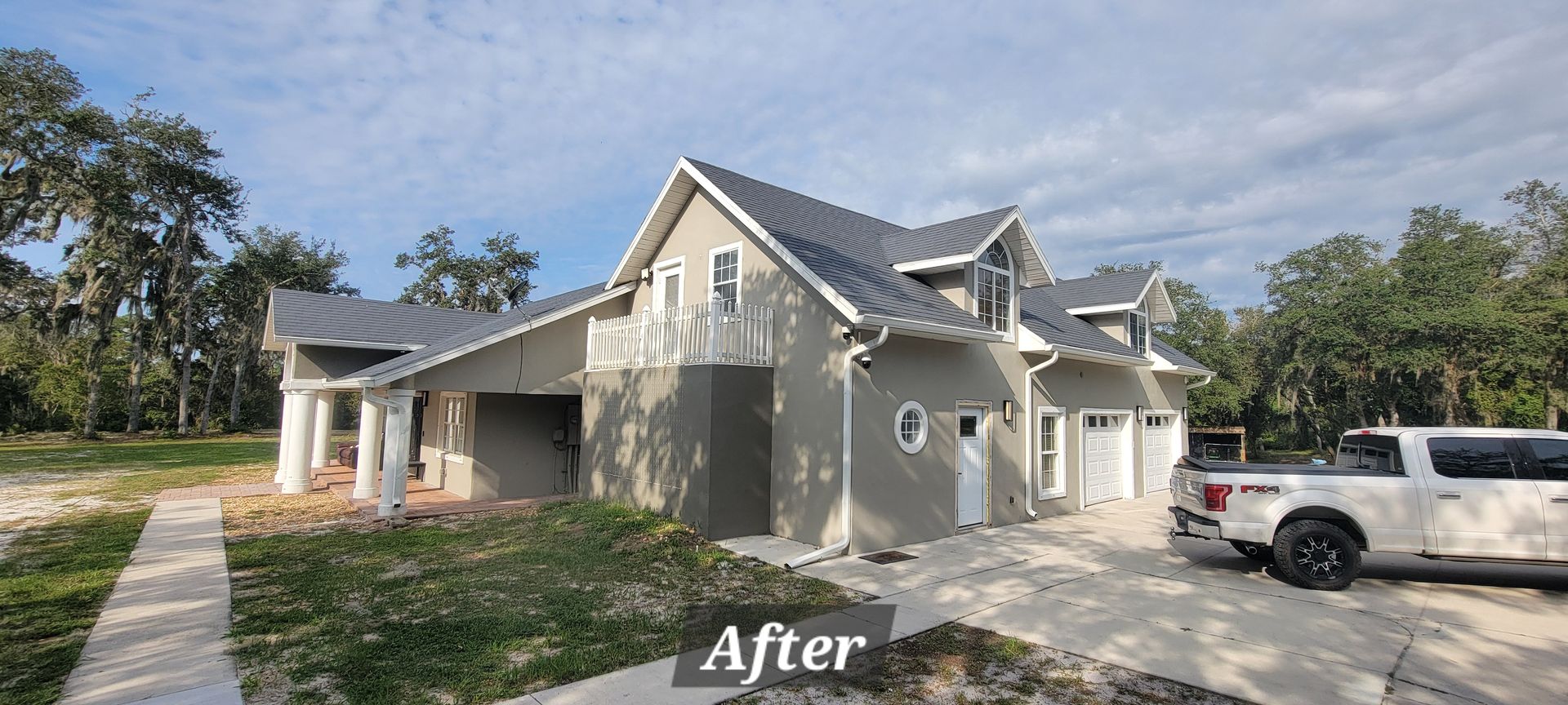 A white truck is parked in front of a house under construction.