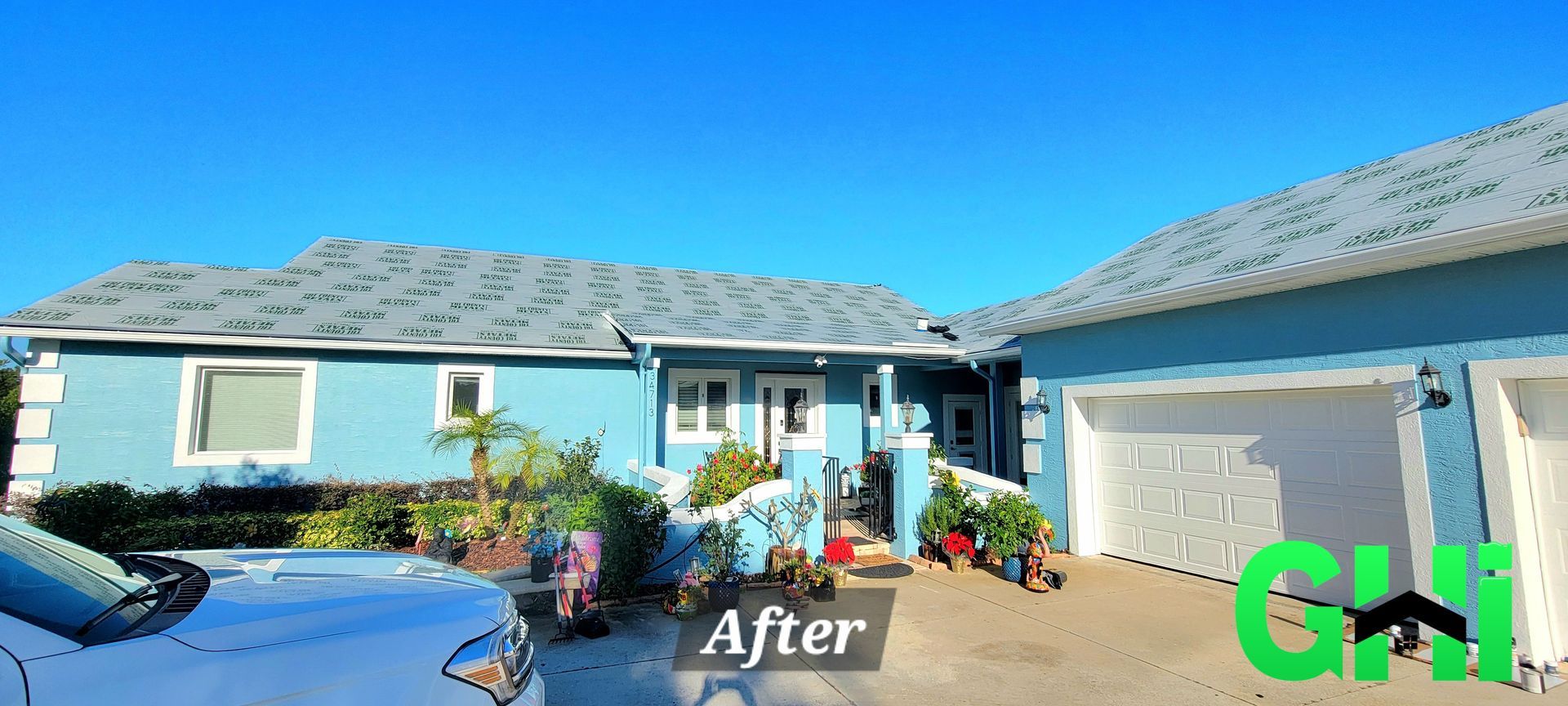 A blue house with a white car parked in front of it.