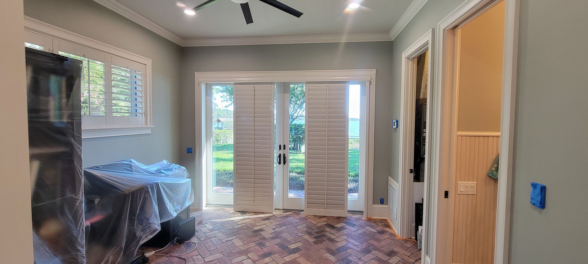 A living room with sliding glass doors and a ceiling fan.