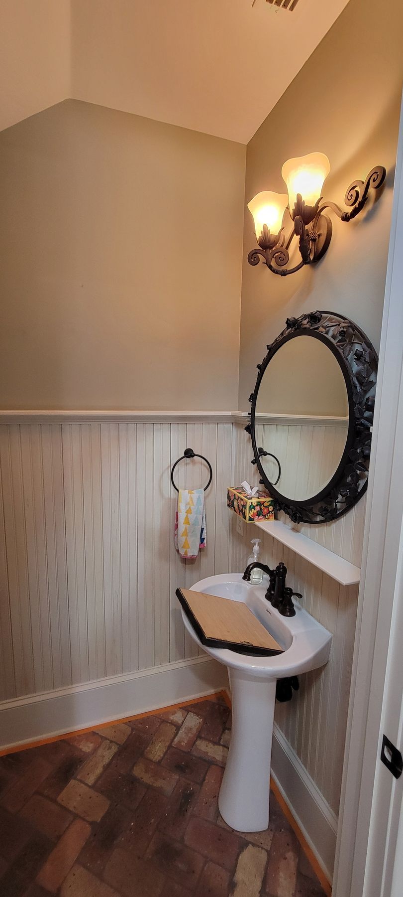 A bathroom with a sink , mirror and light fixtures.