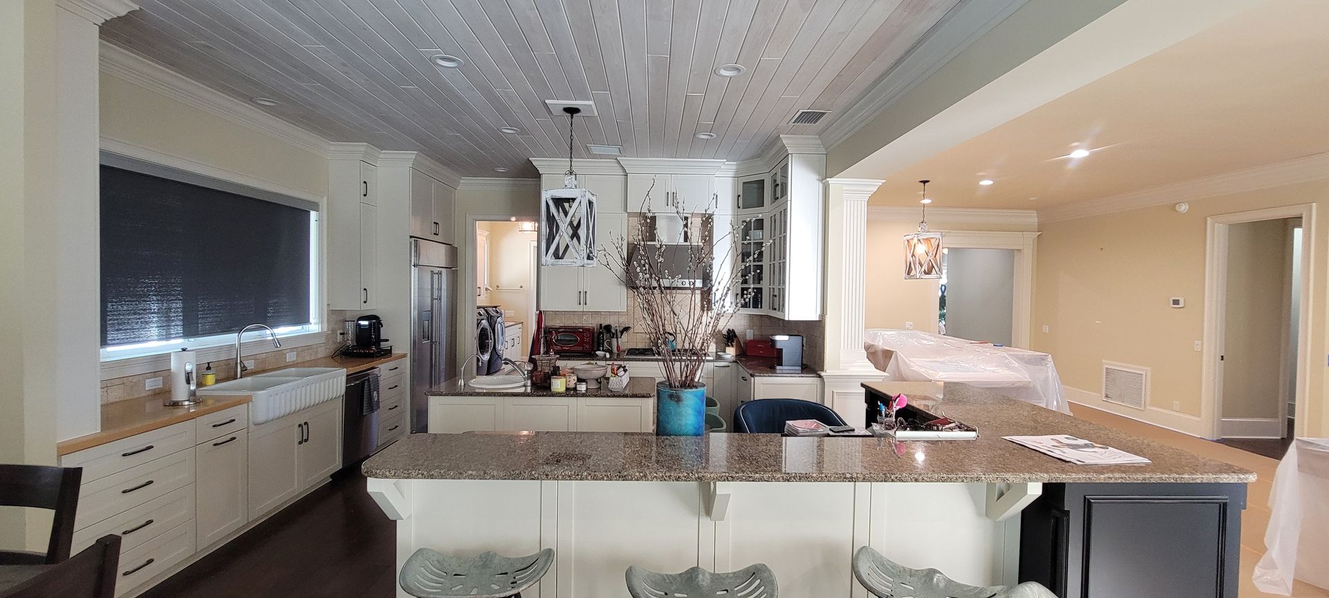 A kitchen with granite counter tops and white cabinets is being remodeled.