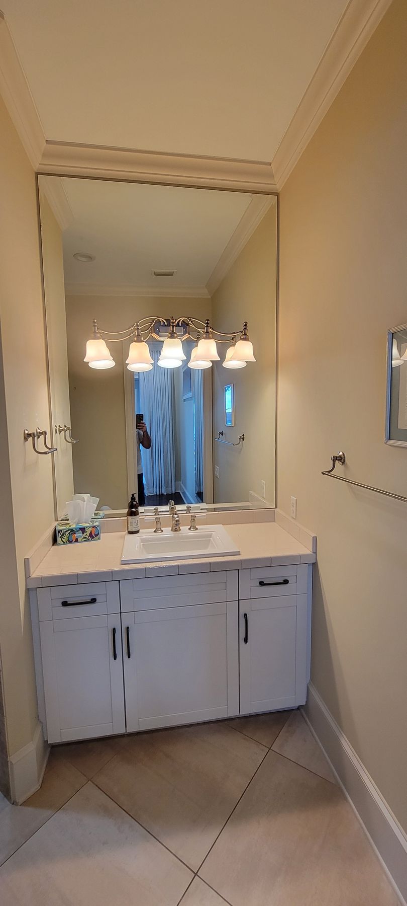 A bathroom with a sink , mirror and cabinets.