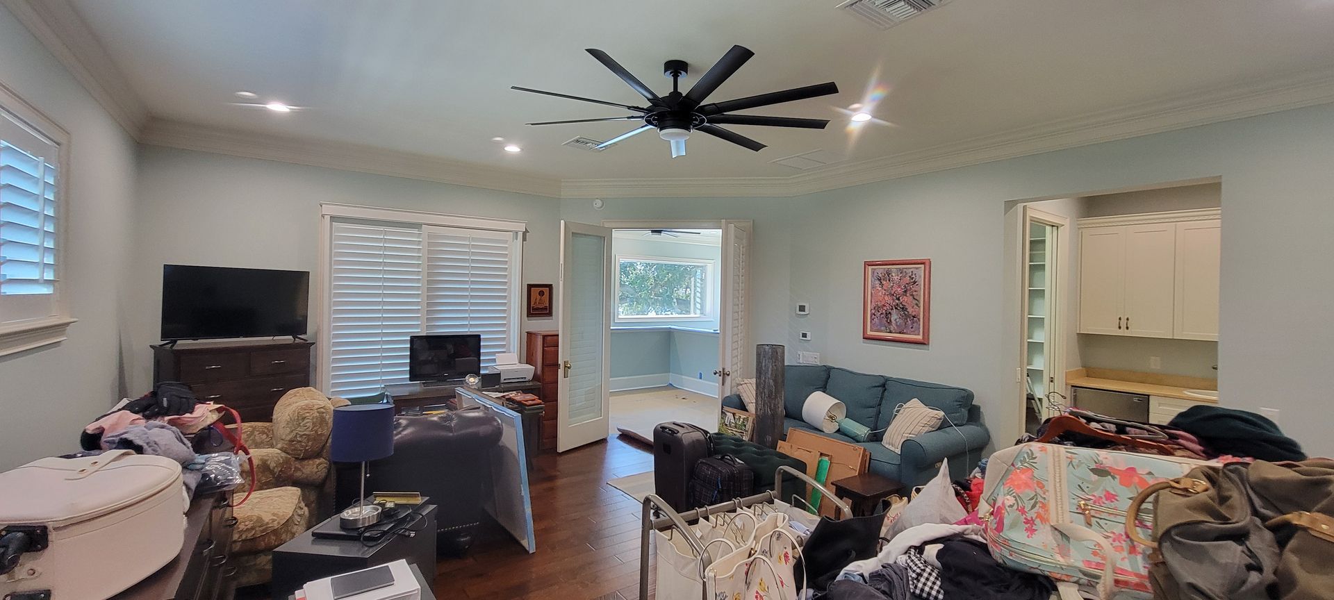 A living room filled with furniture and a ceiling fan.