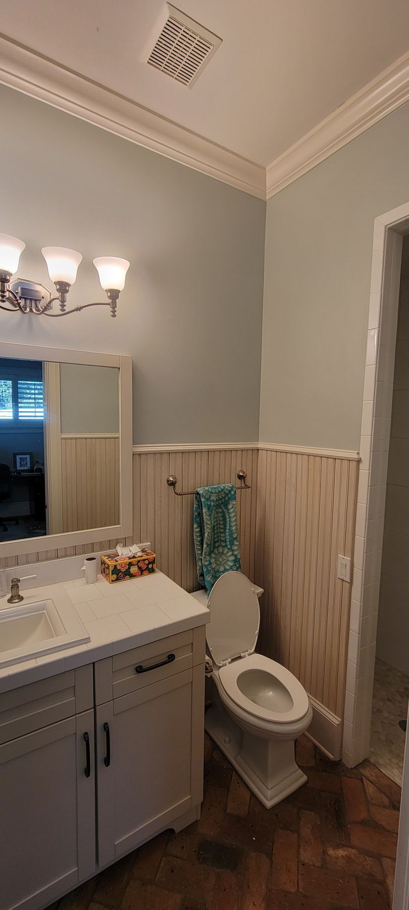 A bathroom with a toilet , sink and mirror.