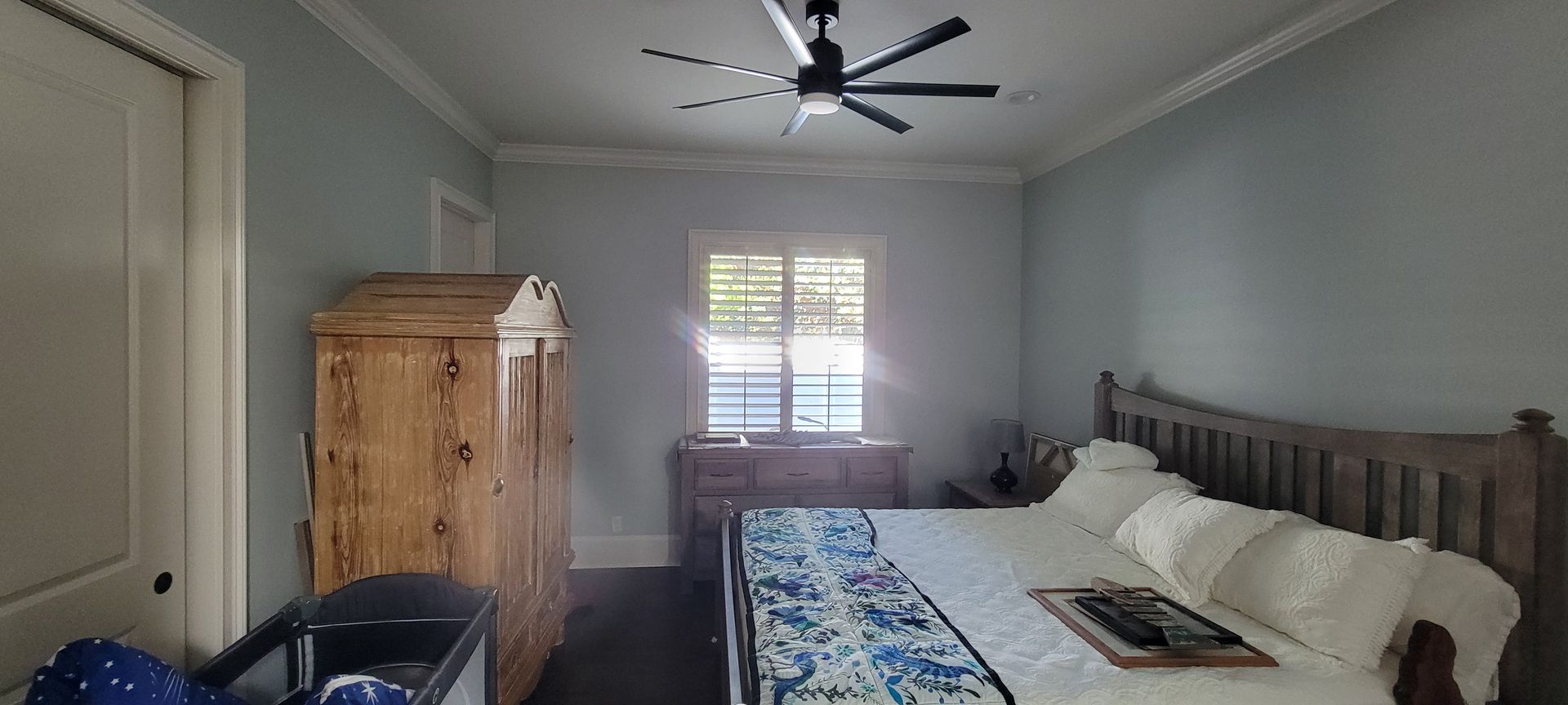 A bedroom with a large bed and a ceiling fan.