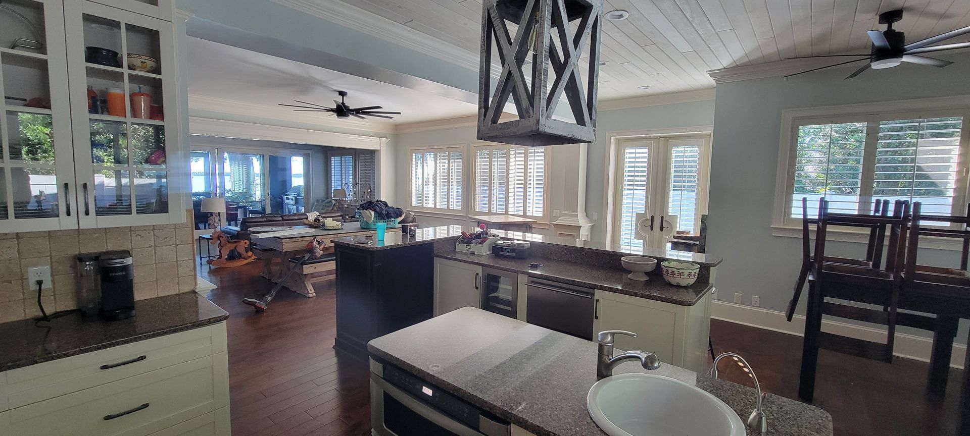 A kitchen with granite counter tops , stainless steel appliances , a sink , and a ceiling fan.