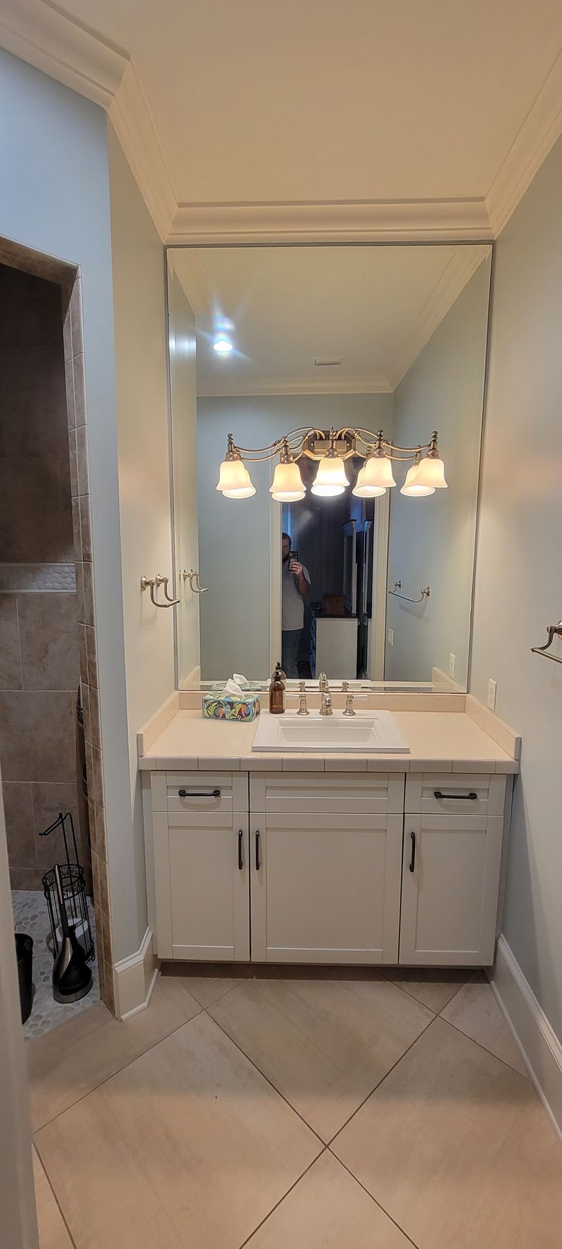 A bathroom with a sink , mirror and cabinets.