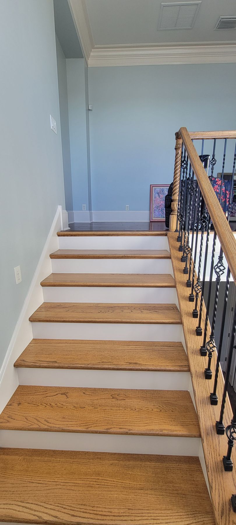 A staircase with wooden steps and a wrought iron railing in a house.