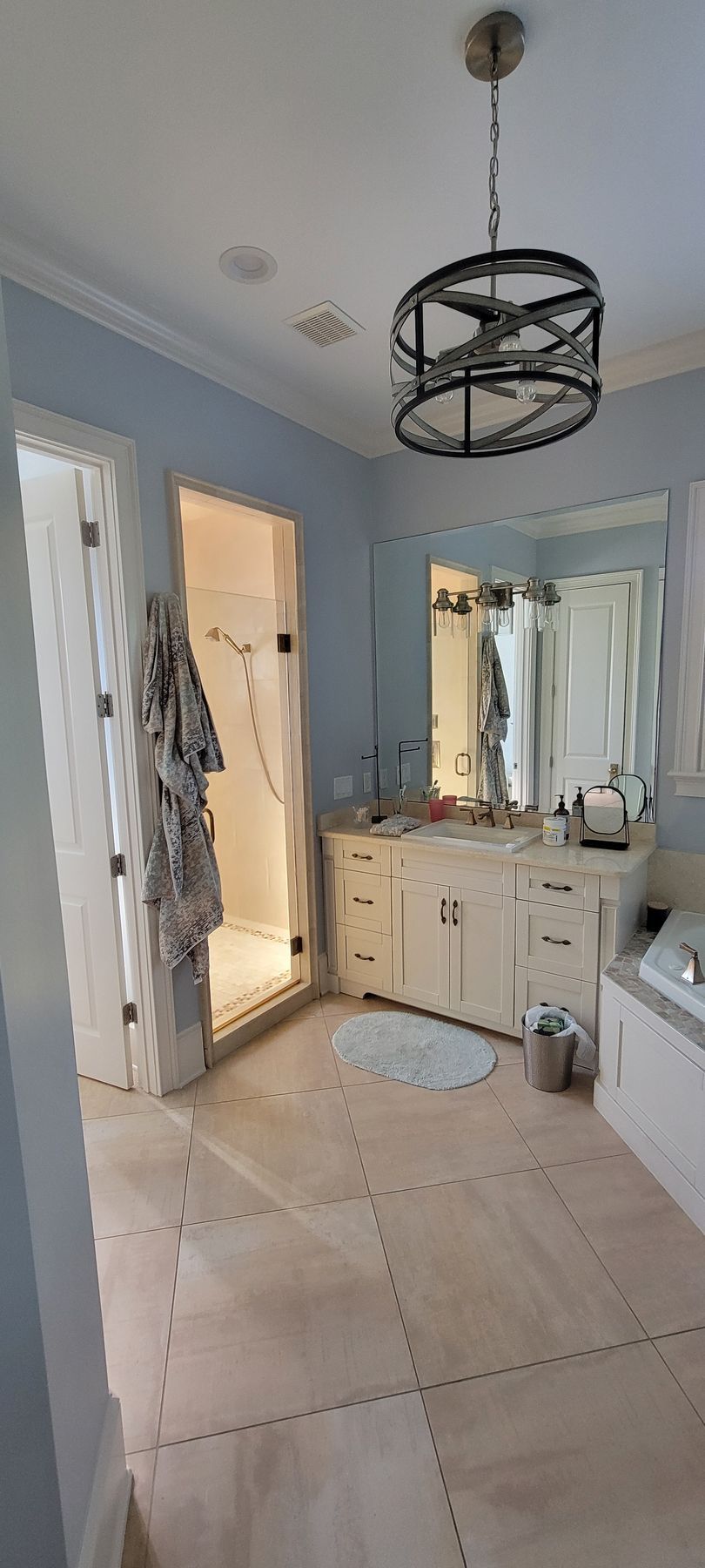 A bathroom with two sinks , a tub , a shower and a mirror.