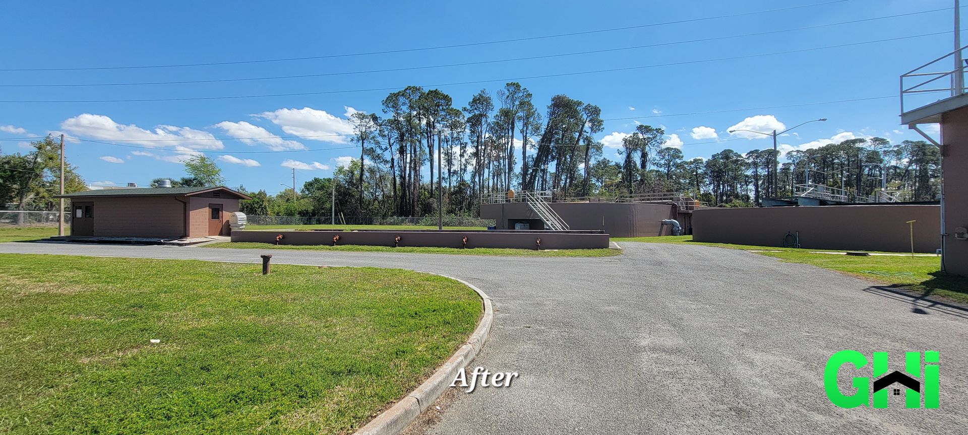 A gravel driveway leading to a house with trees in the background.