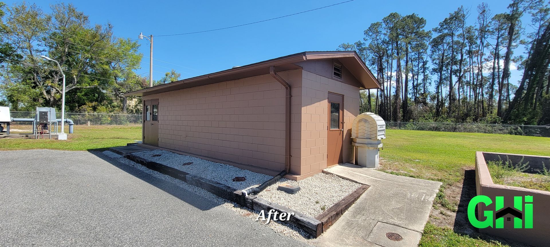 A small shed is sitting in the middle of a grassy field.