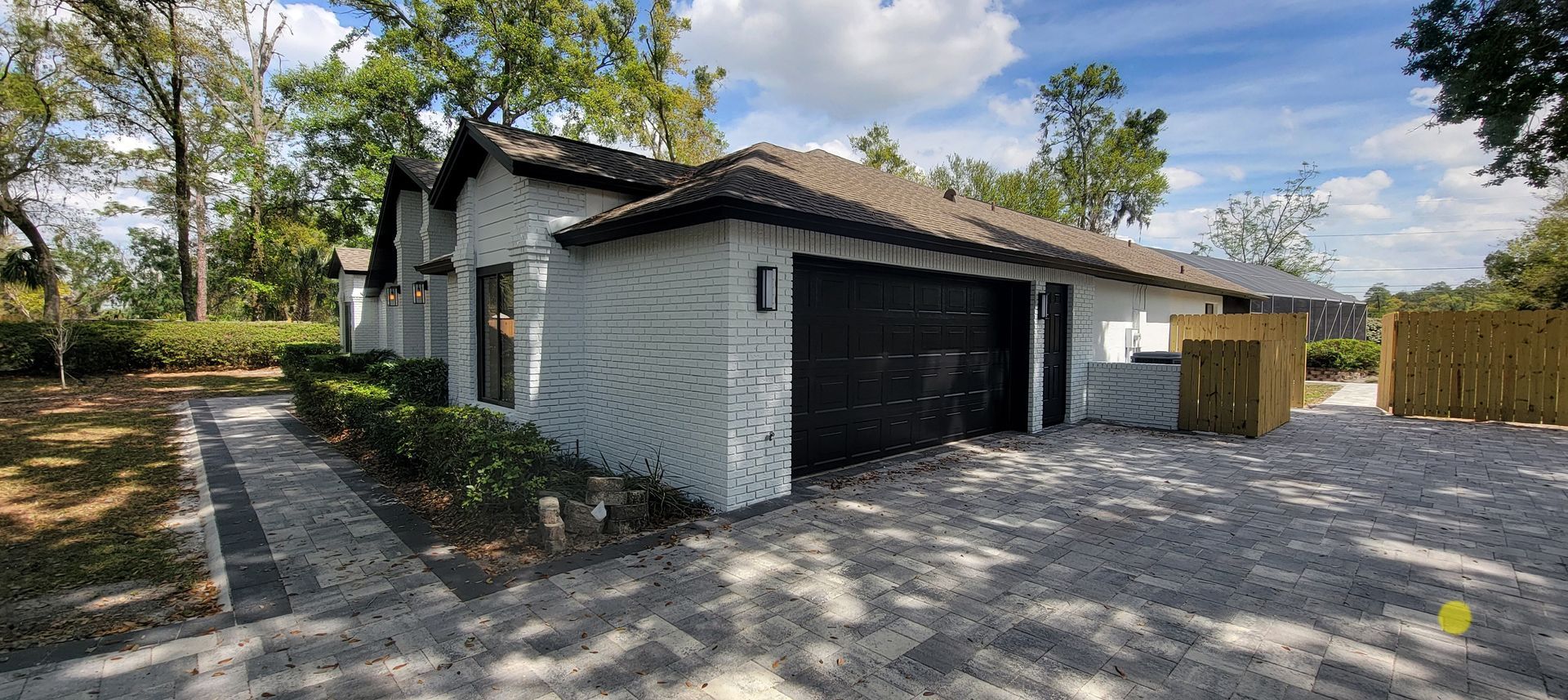 A white house with a black garage door is for sale.