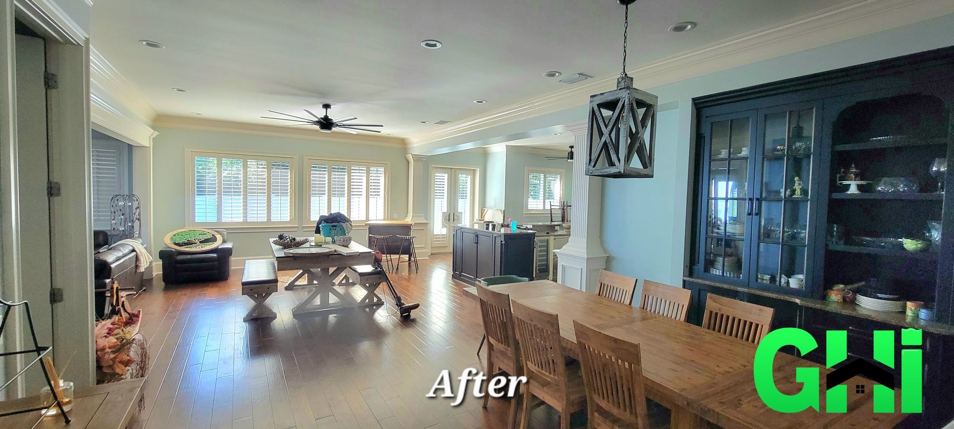 A living room with a dining table and chairs and a hutch.
