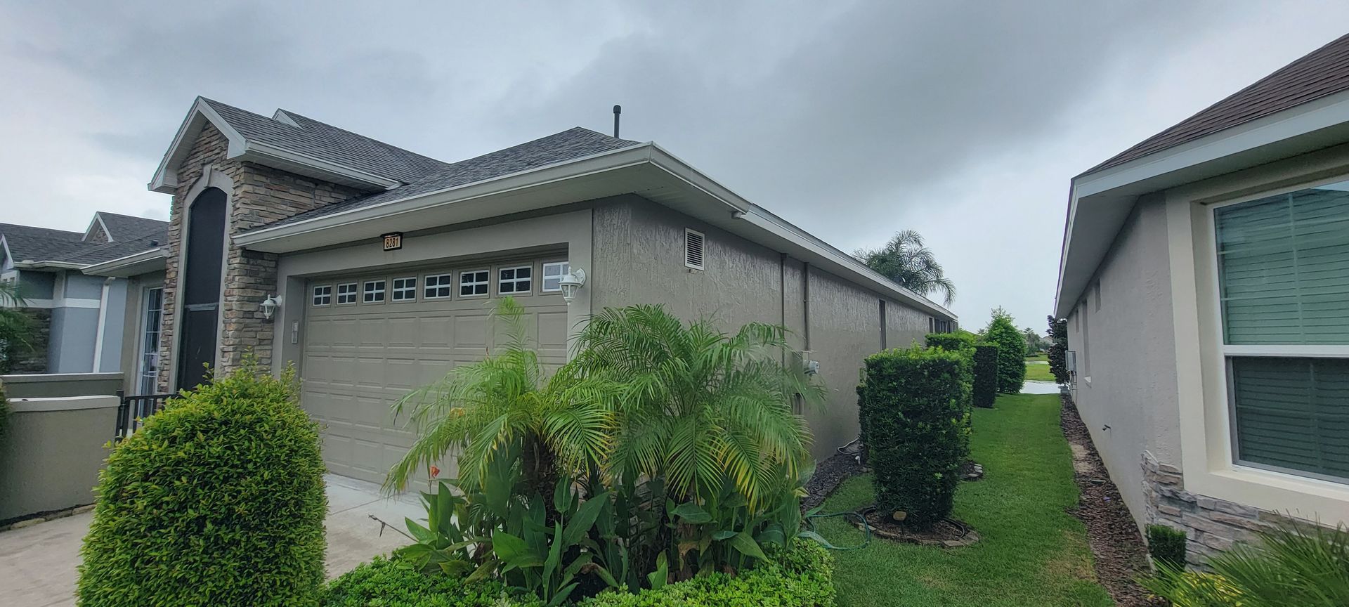 A house with a garage door is sitting next to another house.