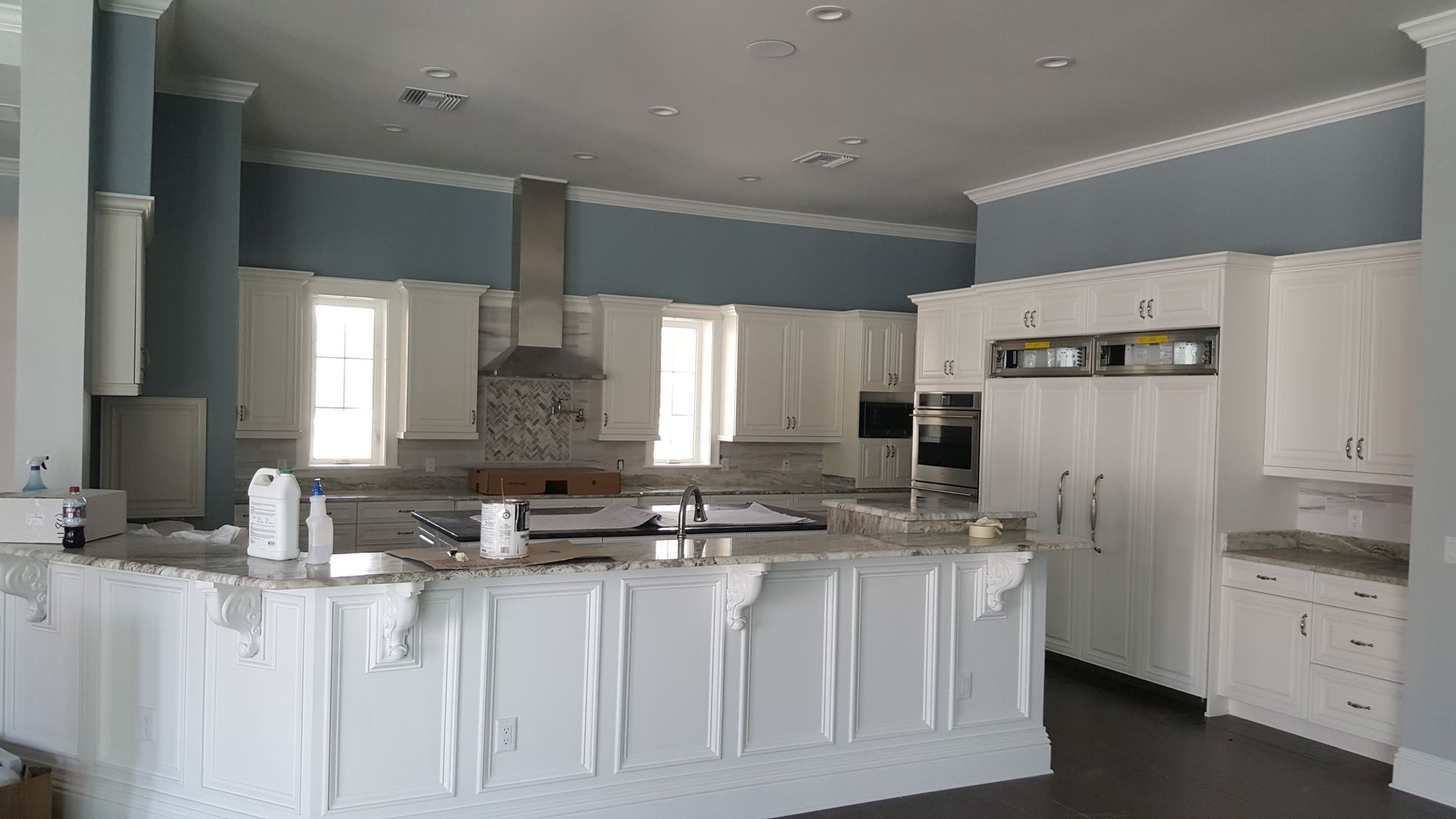 A large kitchen with white cabinets and granite counter tops.