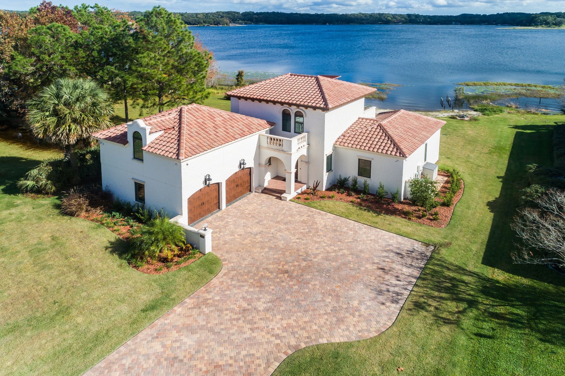 An aerial view of a house with a lake in the background