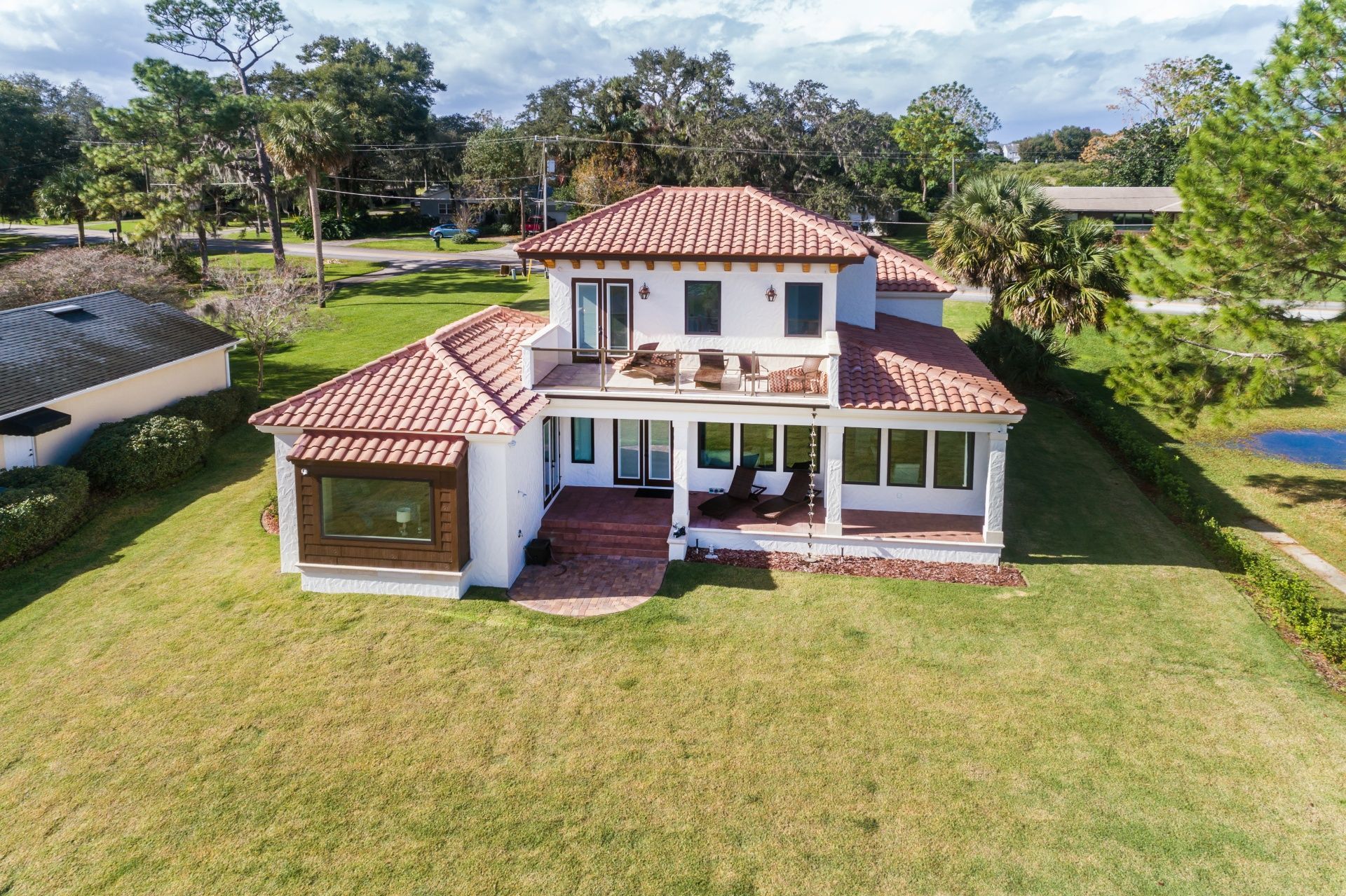 An aerial view of a large white house with a red tile roof