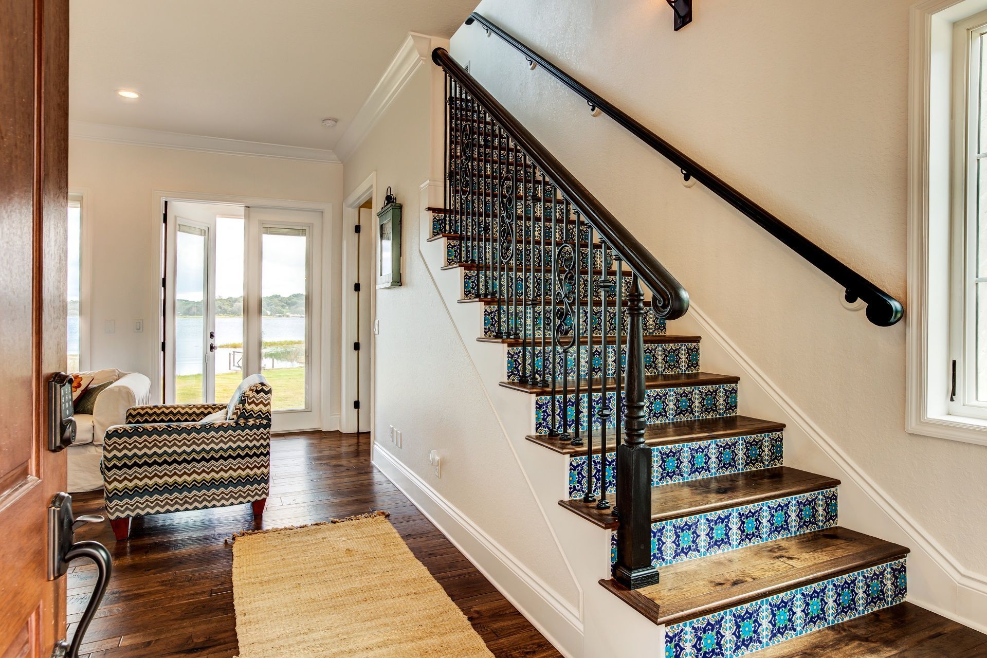 A staircase with blue tile steps and a black railing
