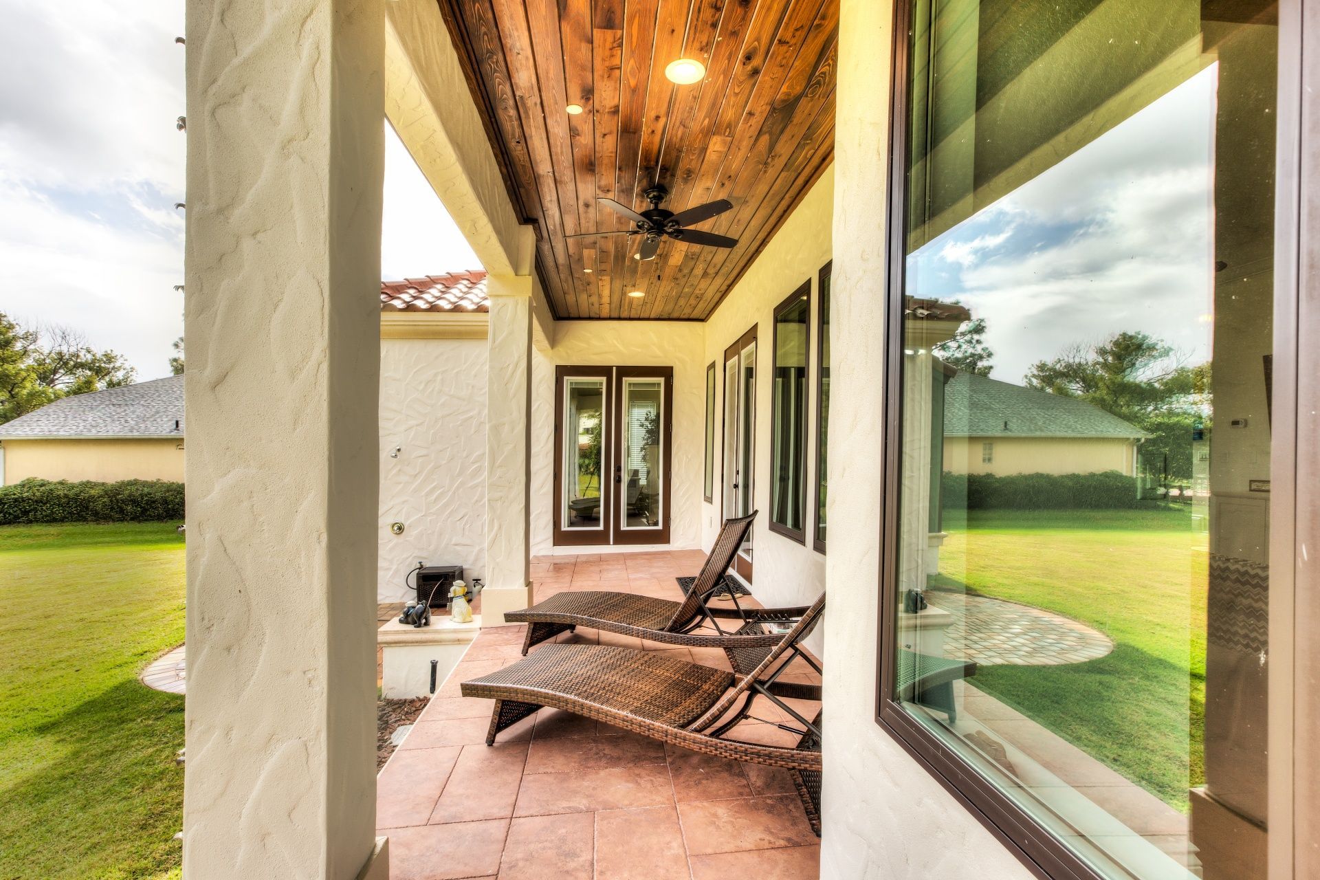 A patio with chairs and a ceiling fan