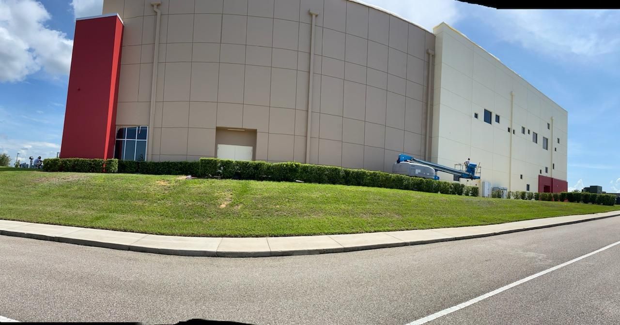 A large white building with a red pillar on the side of it