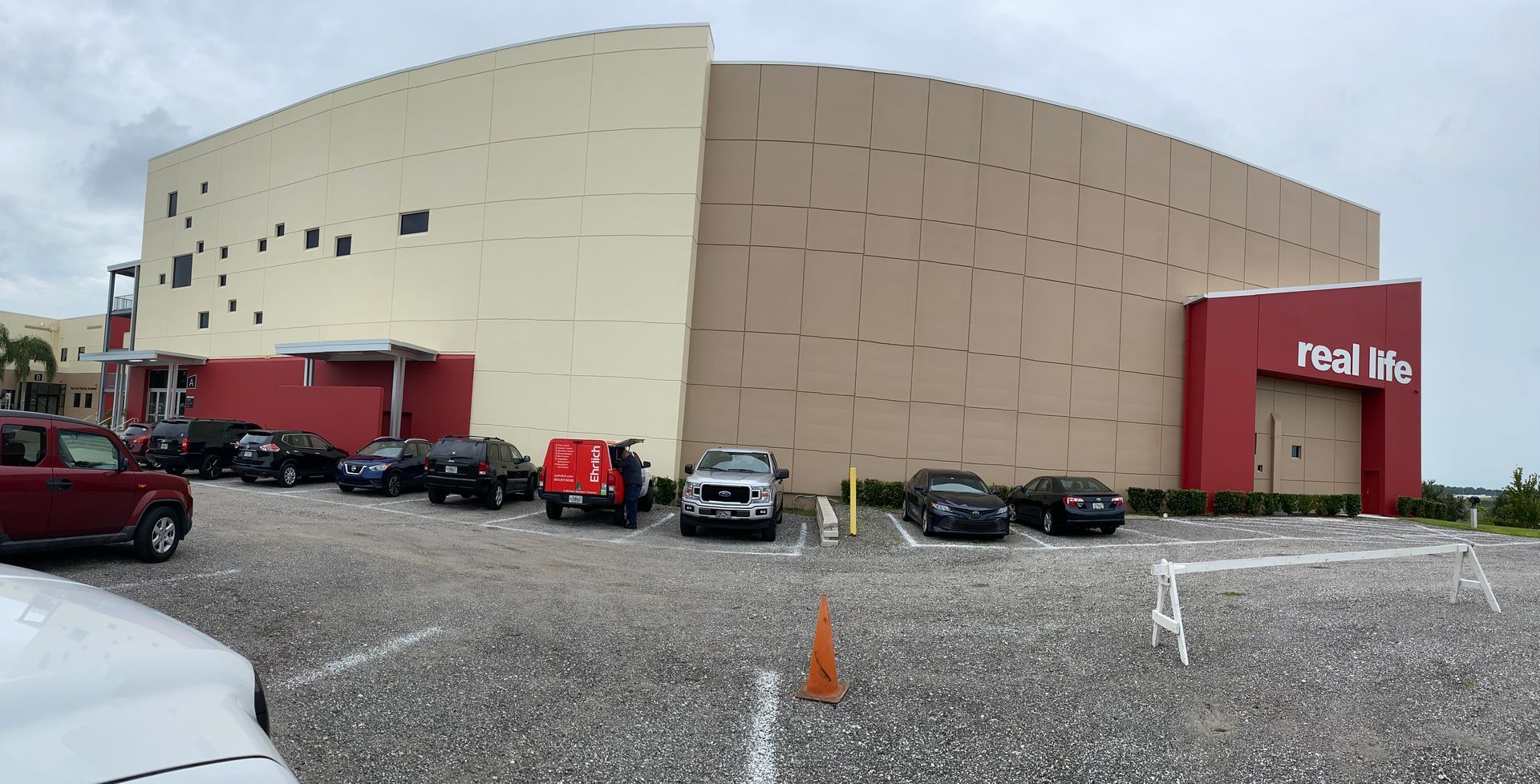 A large building with a lot of cars parked in front of it.