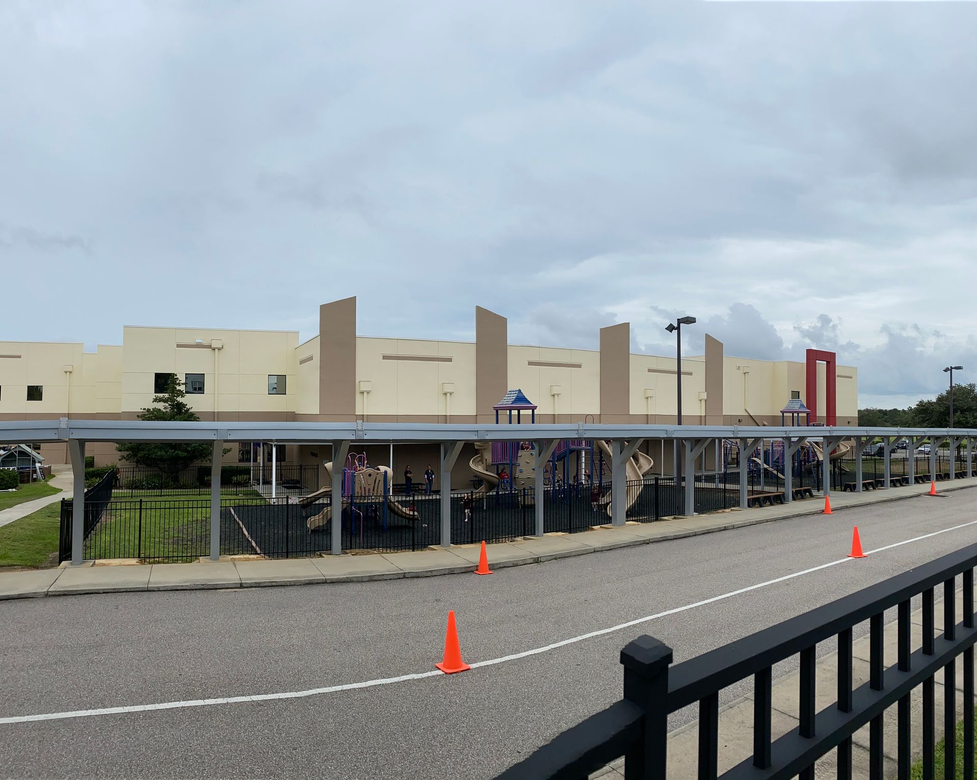 A large building with a fence and cones in front of it