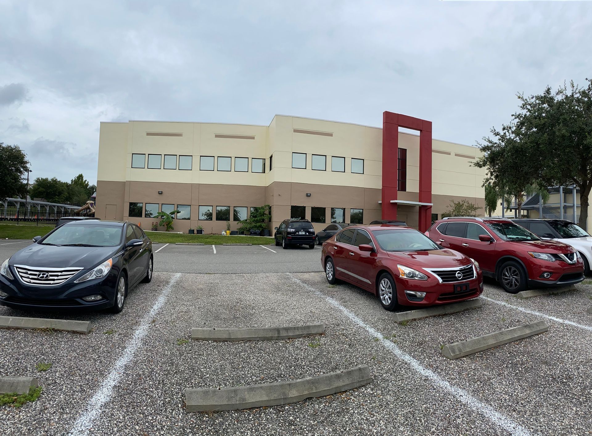 A row of cars are parked in front of a building