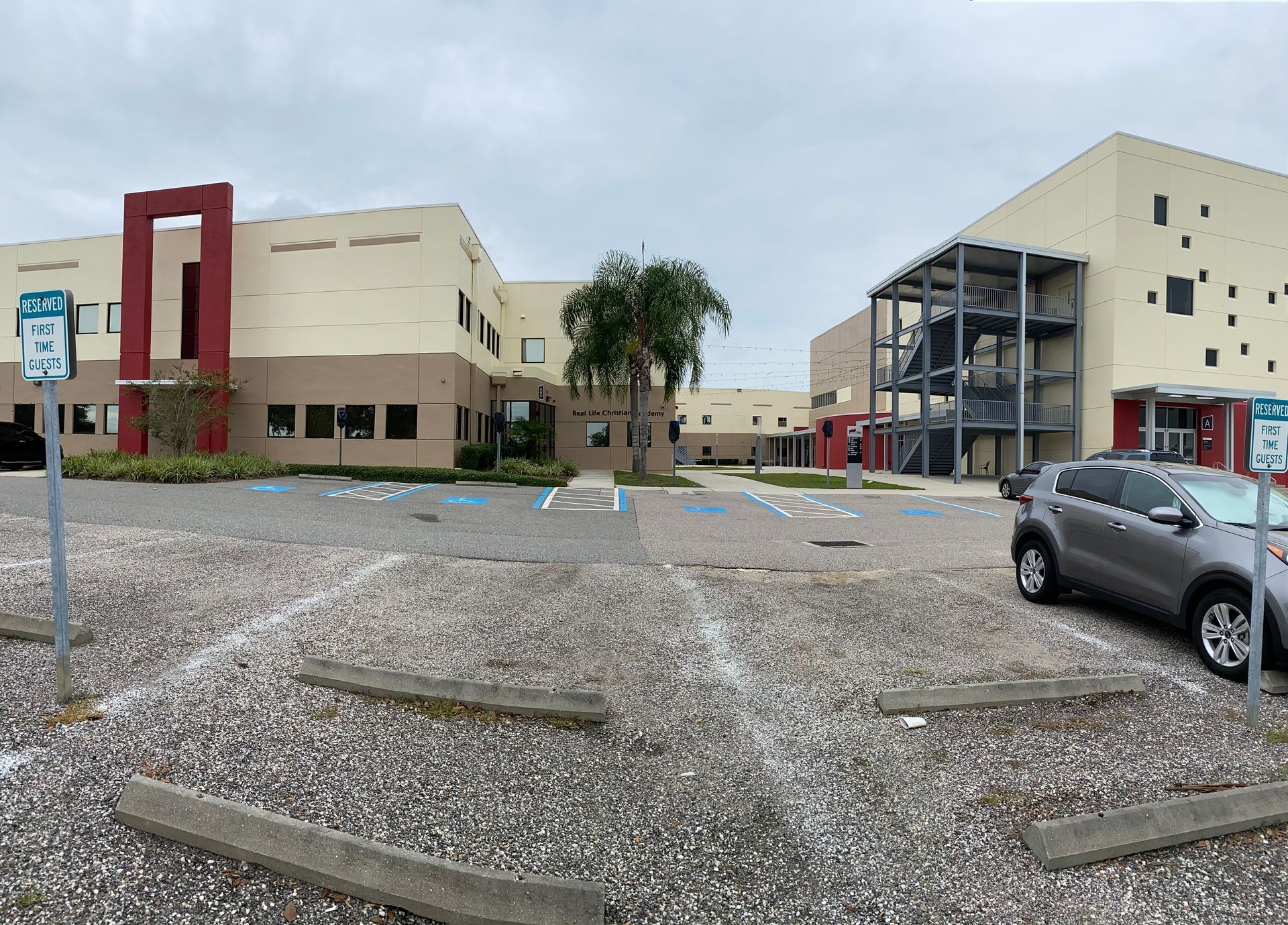 A car is parked in a parking lot in front of a building