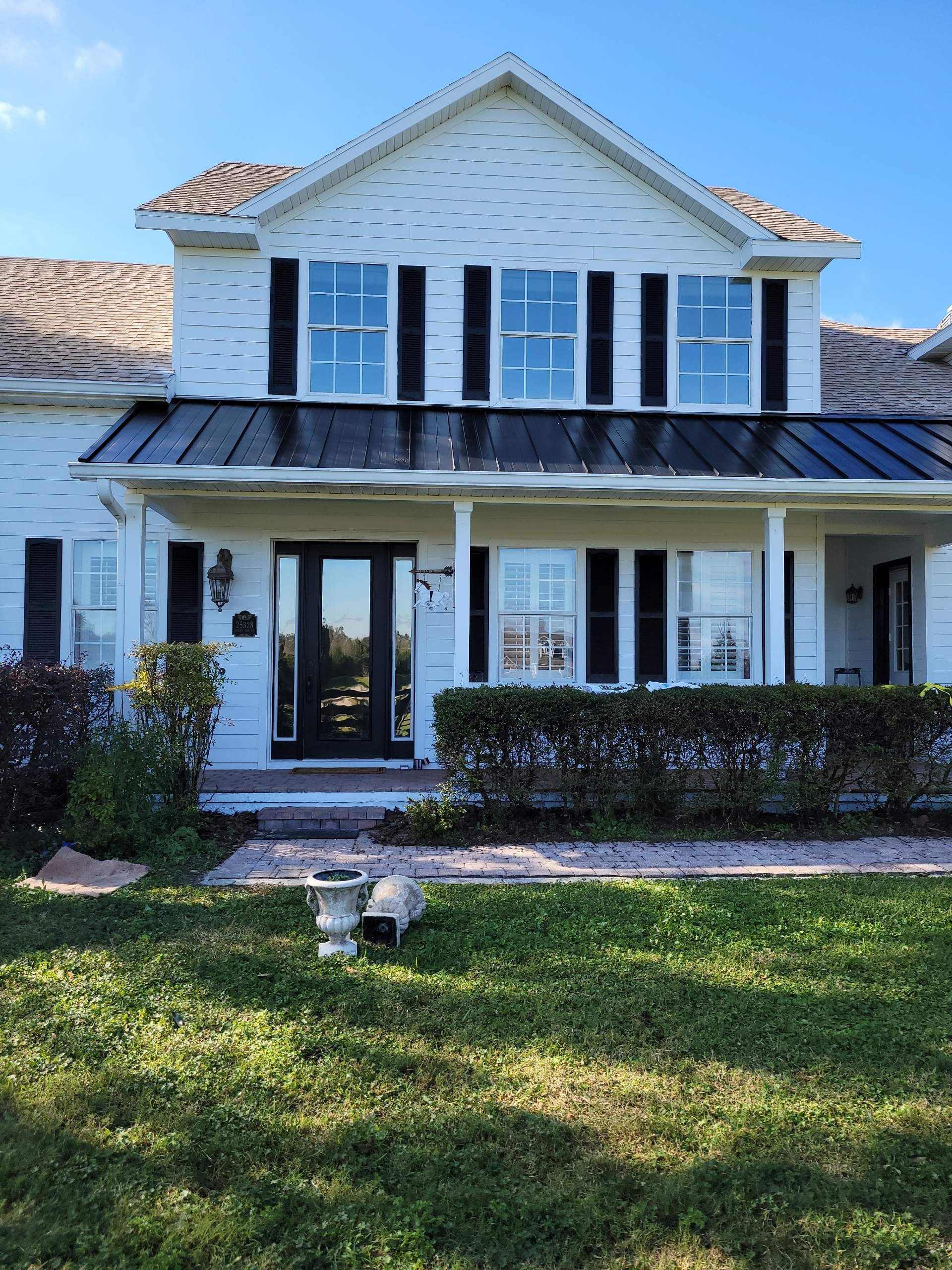 A white house with black shutters and a black roof