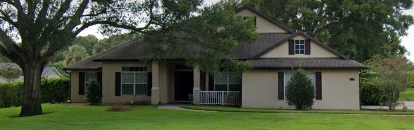 A house with a lot of windows and a tree in front of it