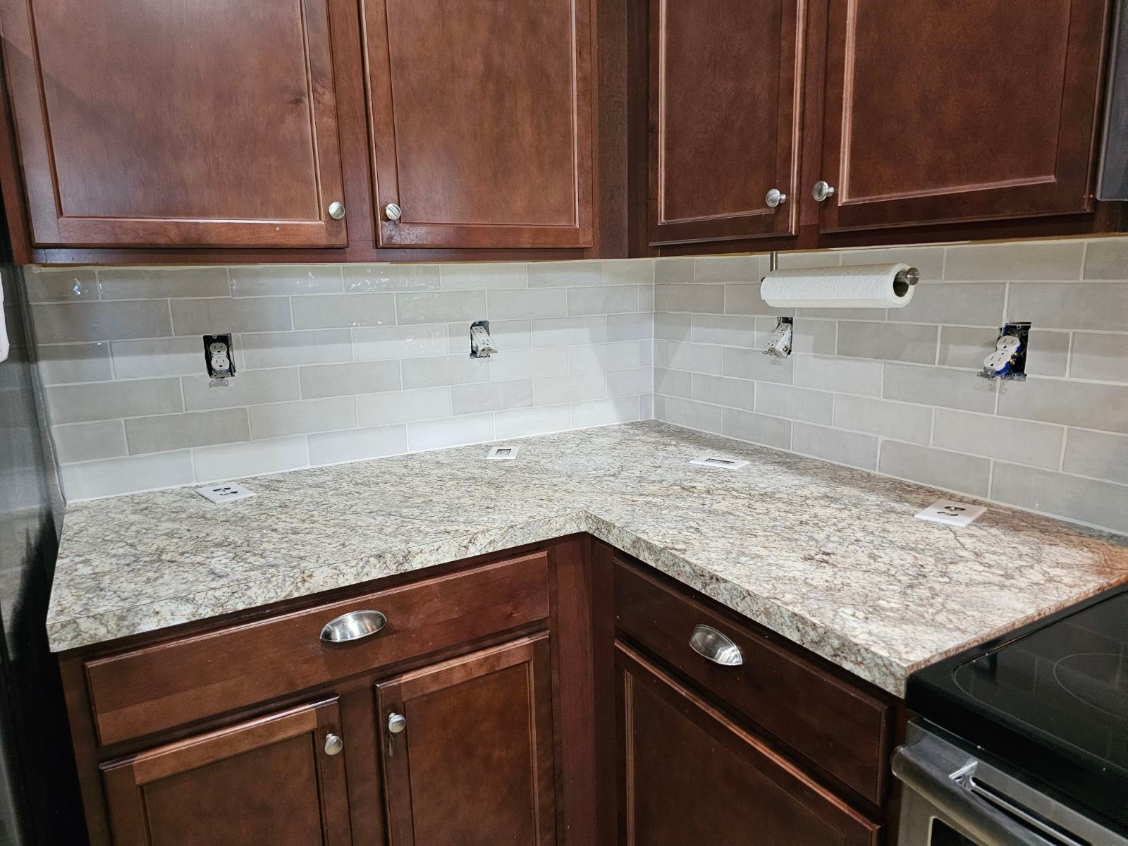 A kitchen with granite counter tops and wooden cabinets.