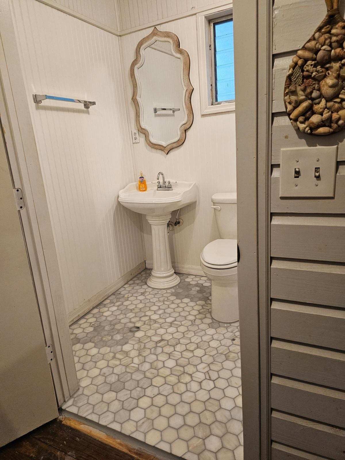 A bathroom with a sink , toilet and mirror.