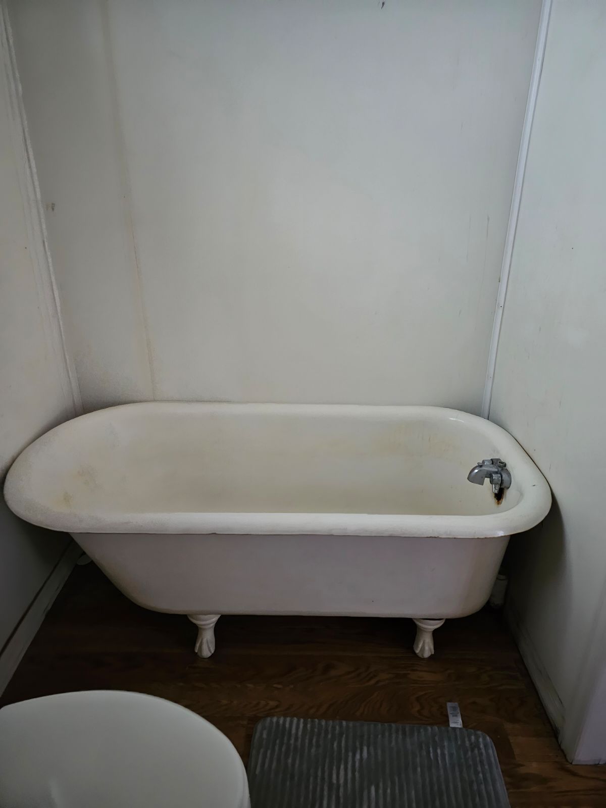 A white bathtub in a bathroom next to a toilet